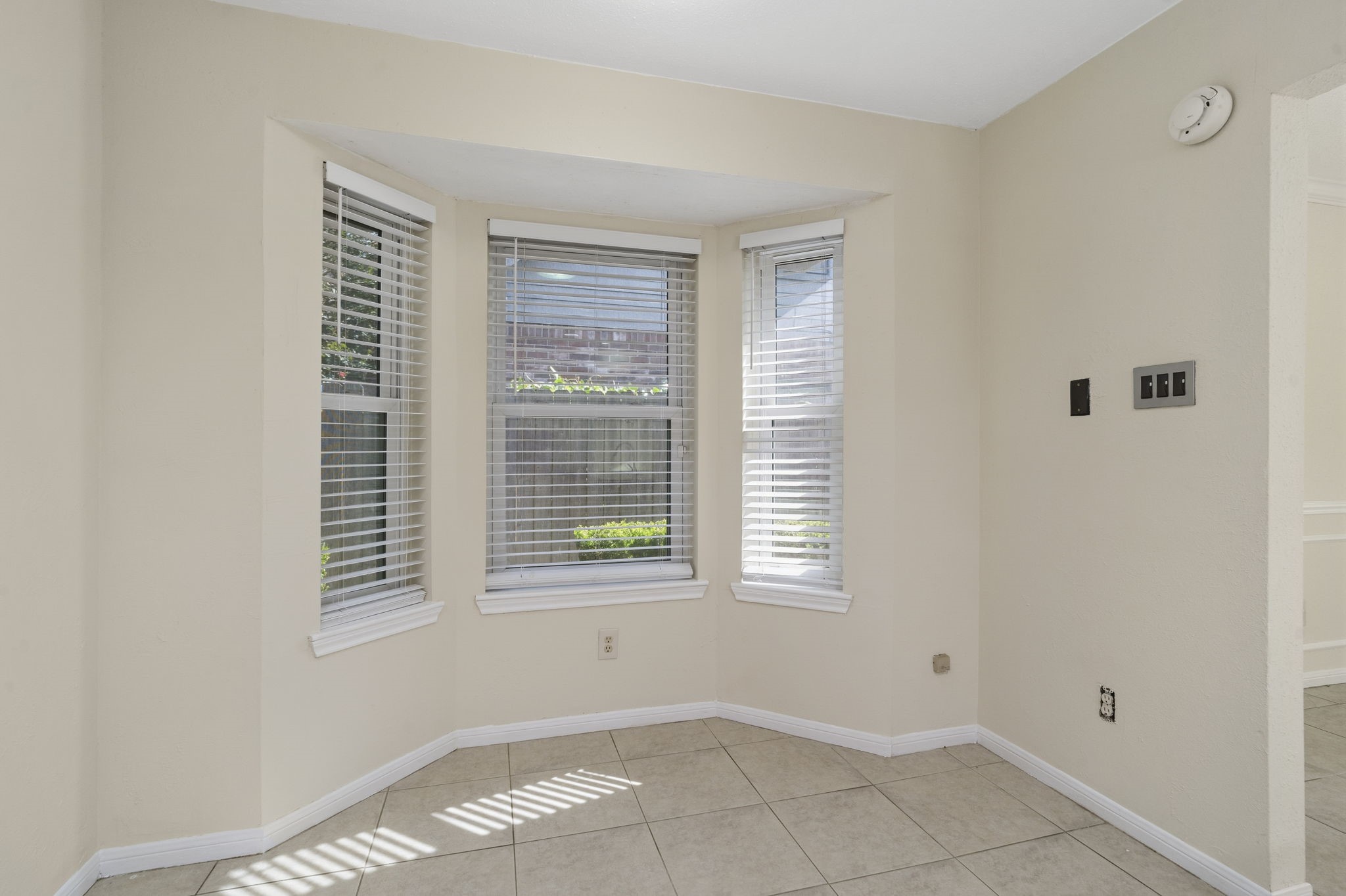 A sun-filled breakfast nook with bay windows creates a bright & inviting space for casual dining just off the kitchen.