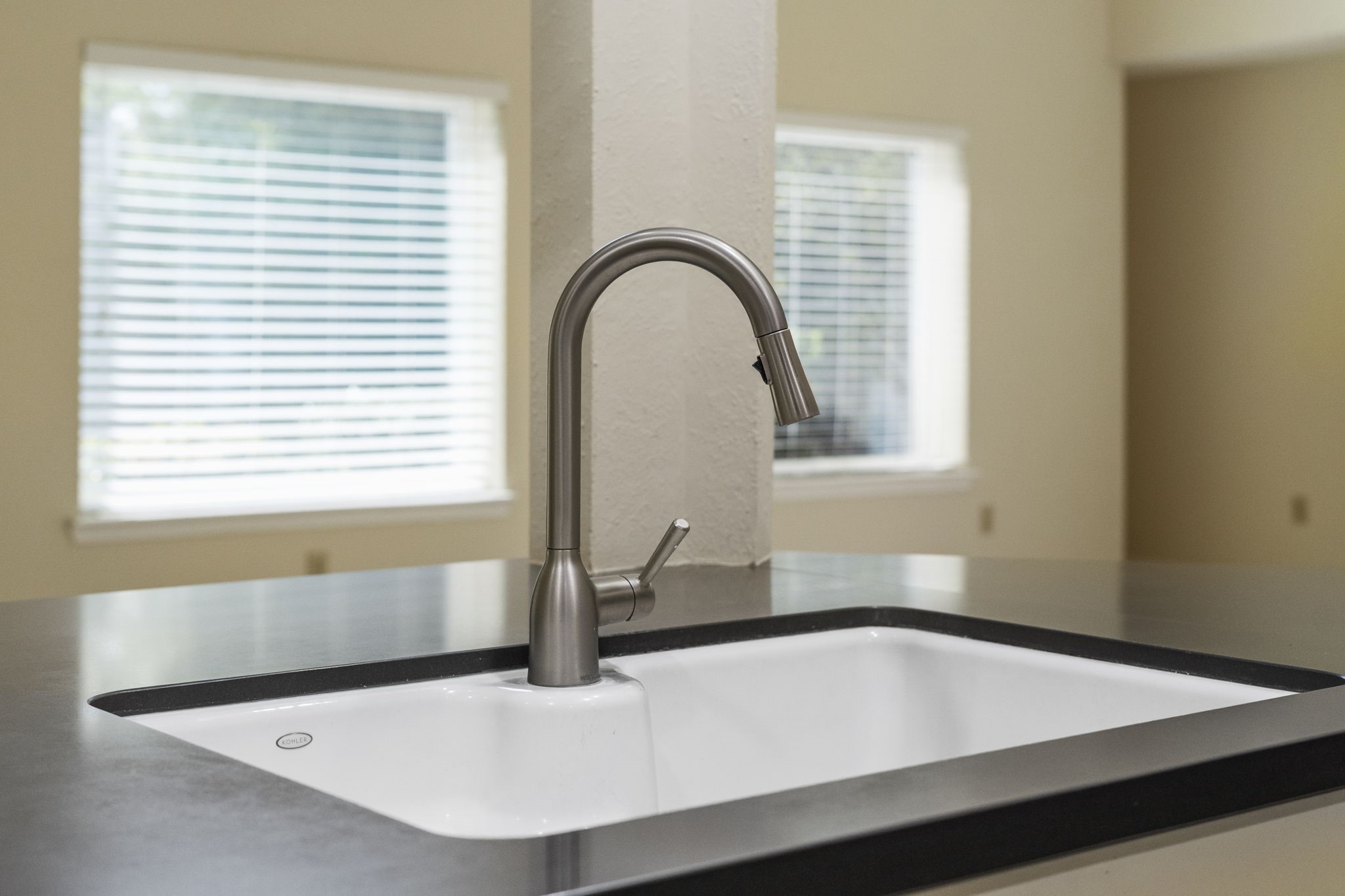 A sleek pull-down faucet & undermount sink offer a clean, modern finish at the kitchens breakfast bar.