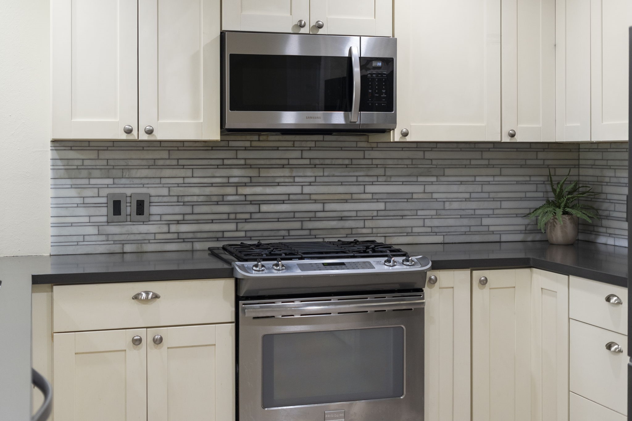 A closer look highlights the linear tile backsplash, adding subtle texture & modern contrast to the kitchens clean design.