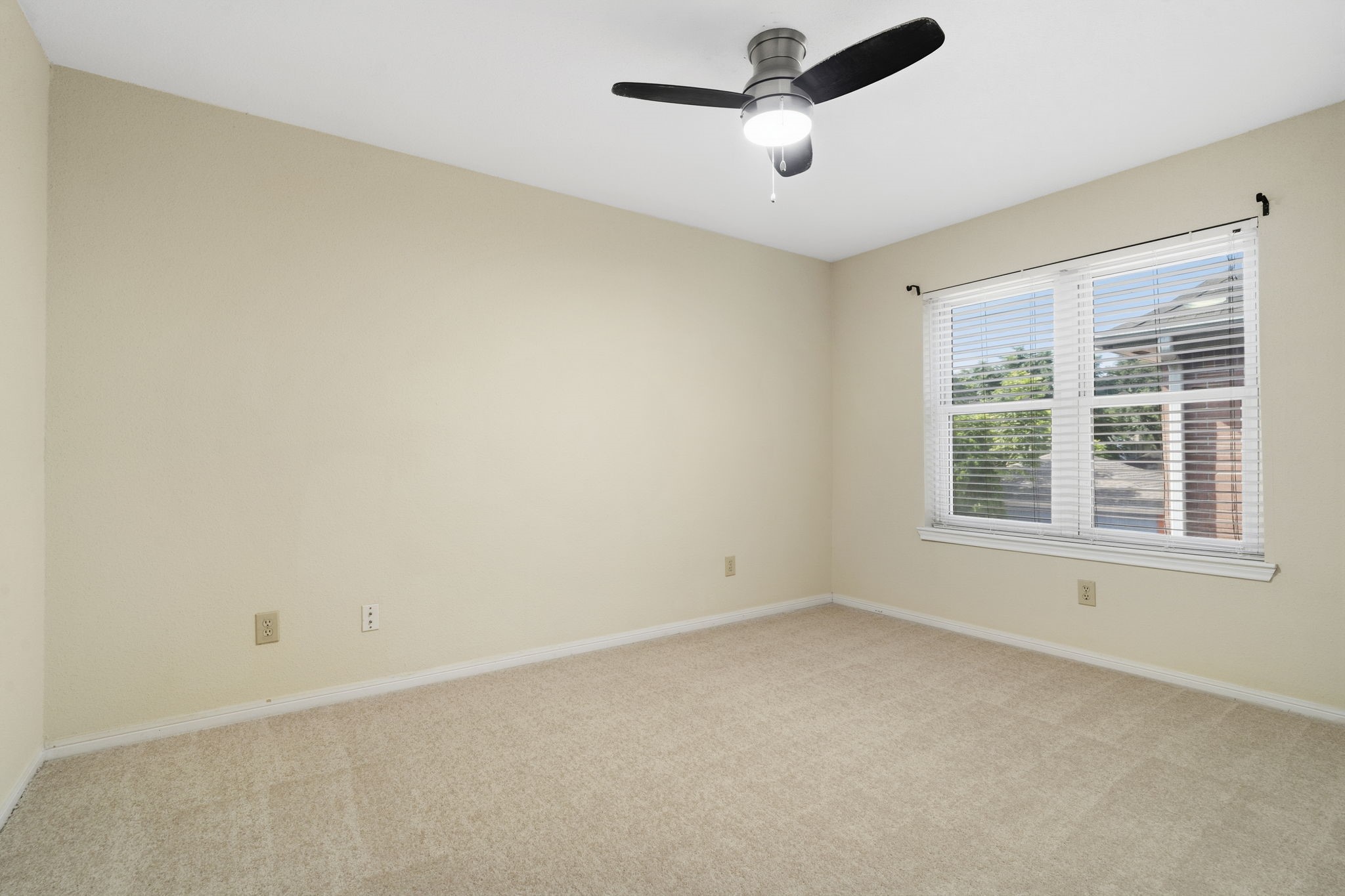 A spacious secondary bedroom with great natural light & a ceiling fan.
