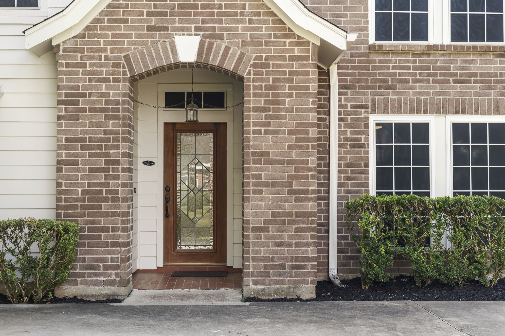A covered brick entry & warm wood front door create an inviting welcome, setting the tone for the homes classic style. A covered brick entry & warm wood front door create an inviting welcome, setting the tone for the homes classic style.