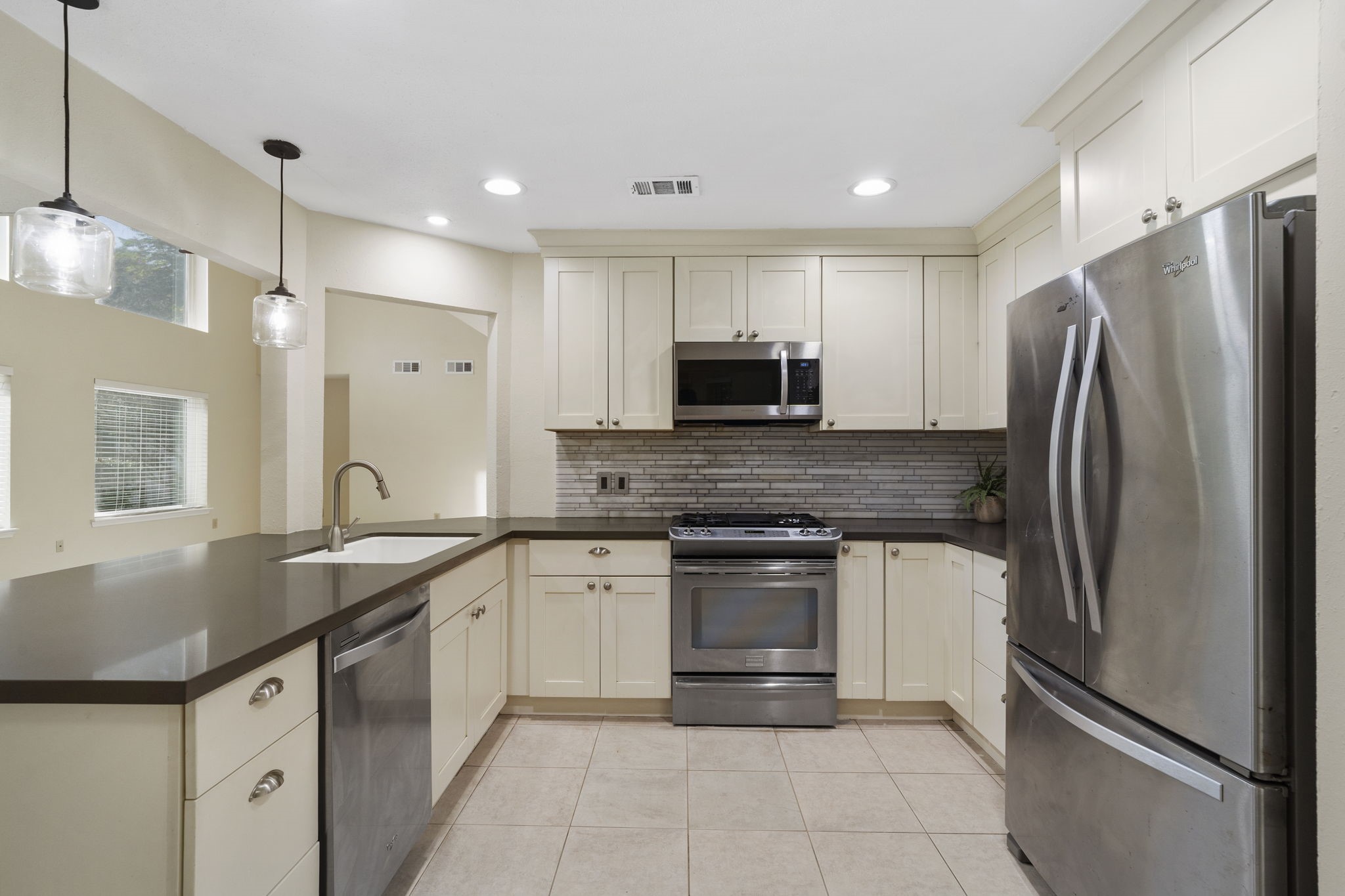 Modern pendant & recessed lighting brighten the kitchen.