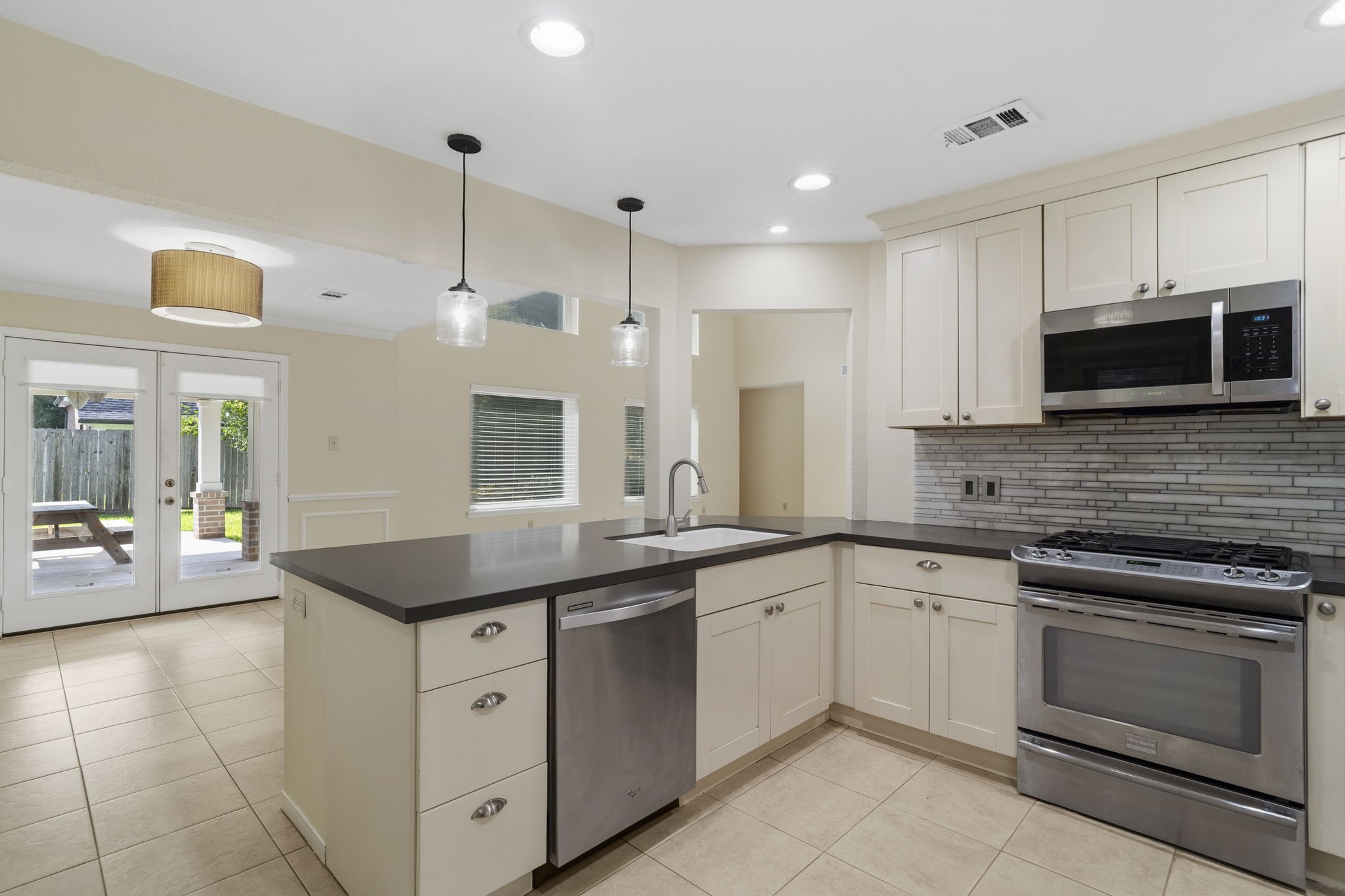 The open kitchen design keeps everything connected, with clear sightlines to the dining area & easy access to the covered back patio.