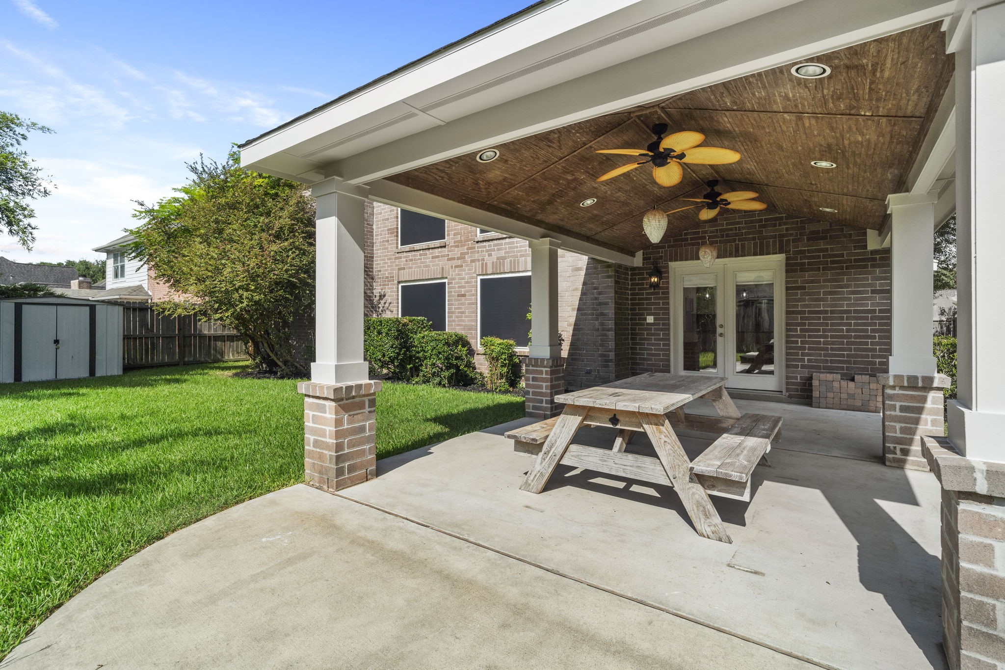 You're right  we need each caption to add something new.

For this angle, Id use:

**French doors provide easy access from the home to the backyard & covered patio.