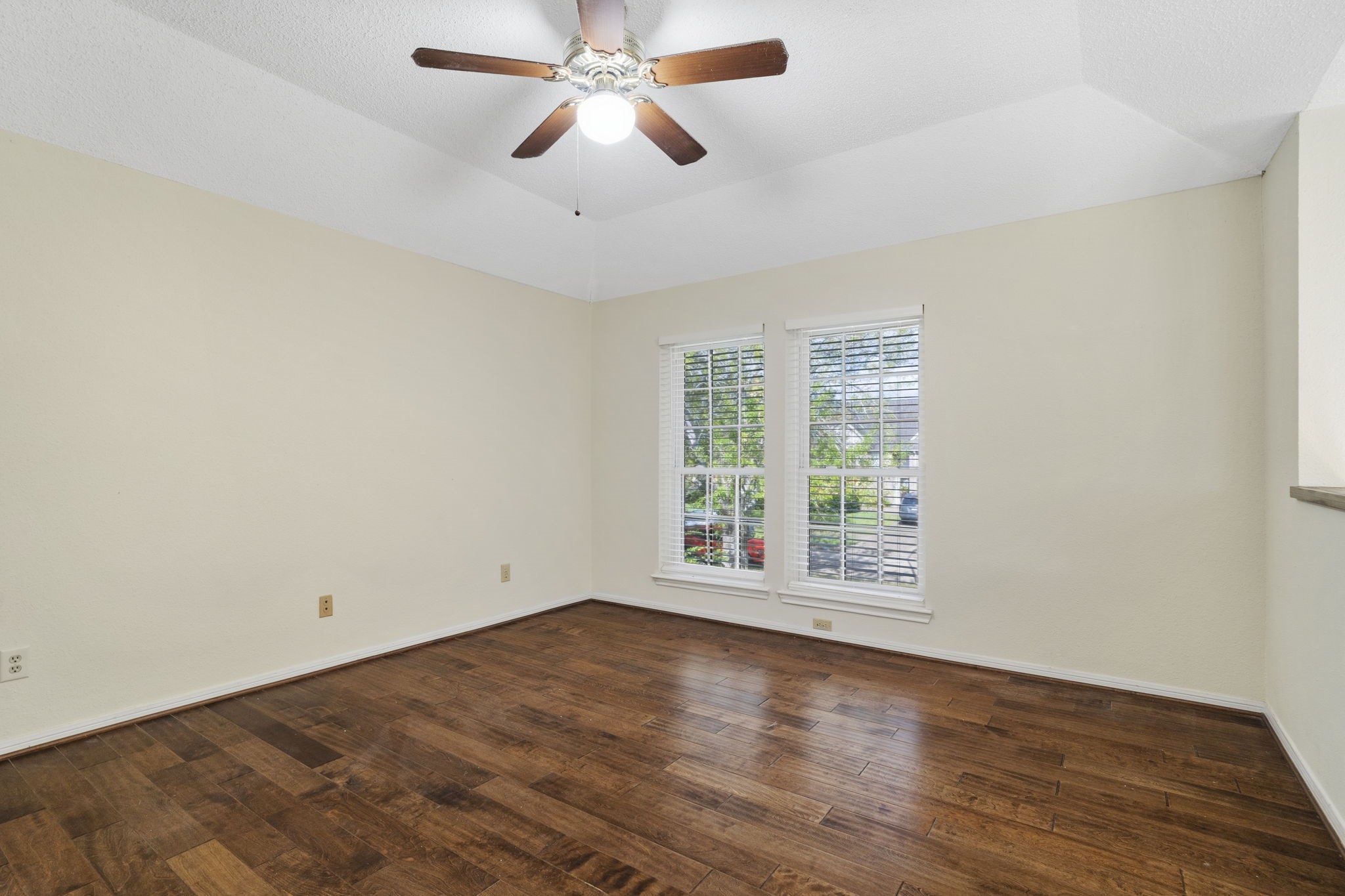 Spacious game room with hardwood flooring, a vaulted ceiling & plenty of natural light.