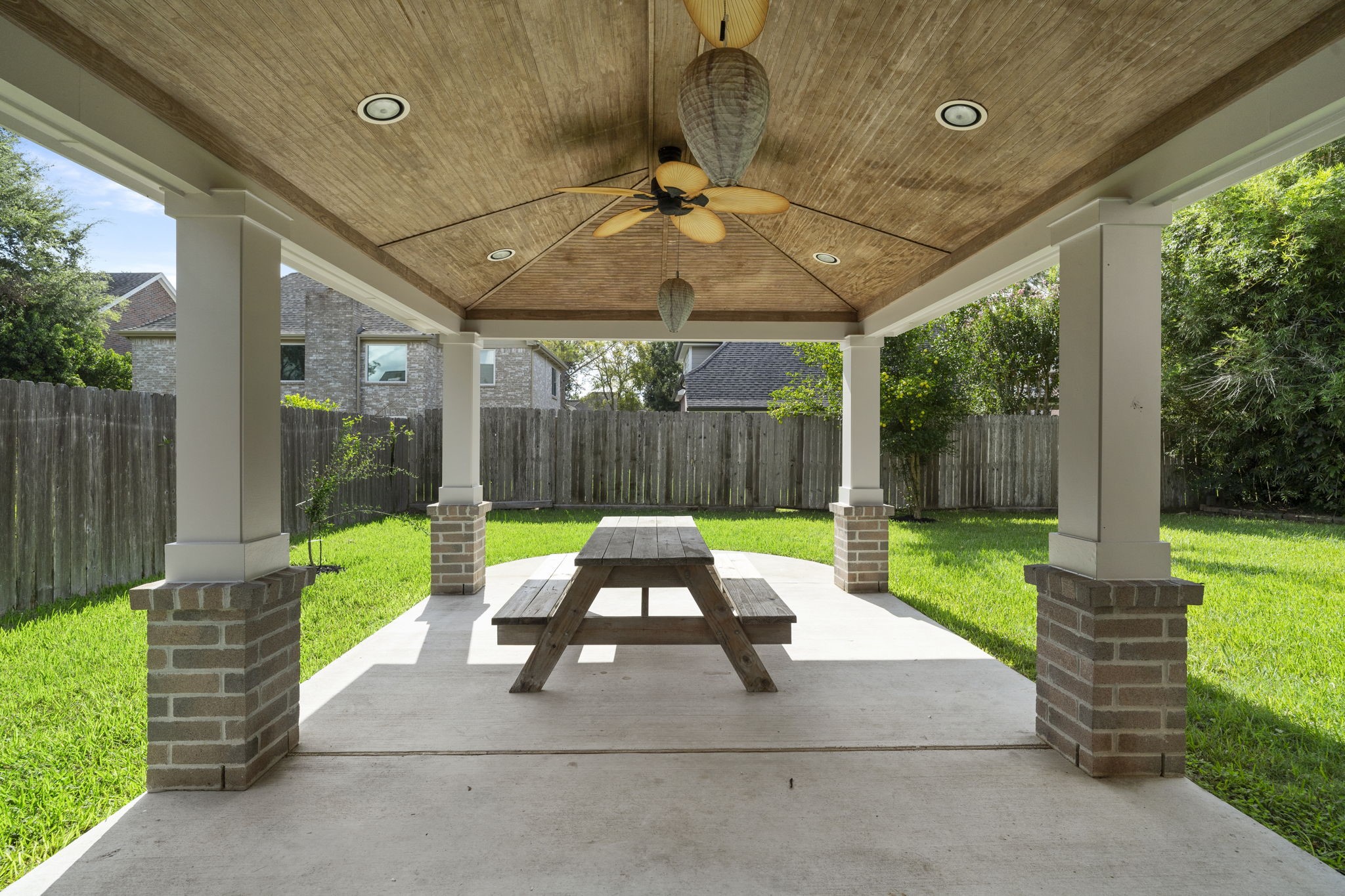 Expansive covered patio with a wood-planked ceiling & plenty of space for outdoor dining & relaxing.