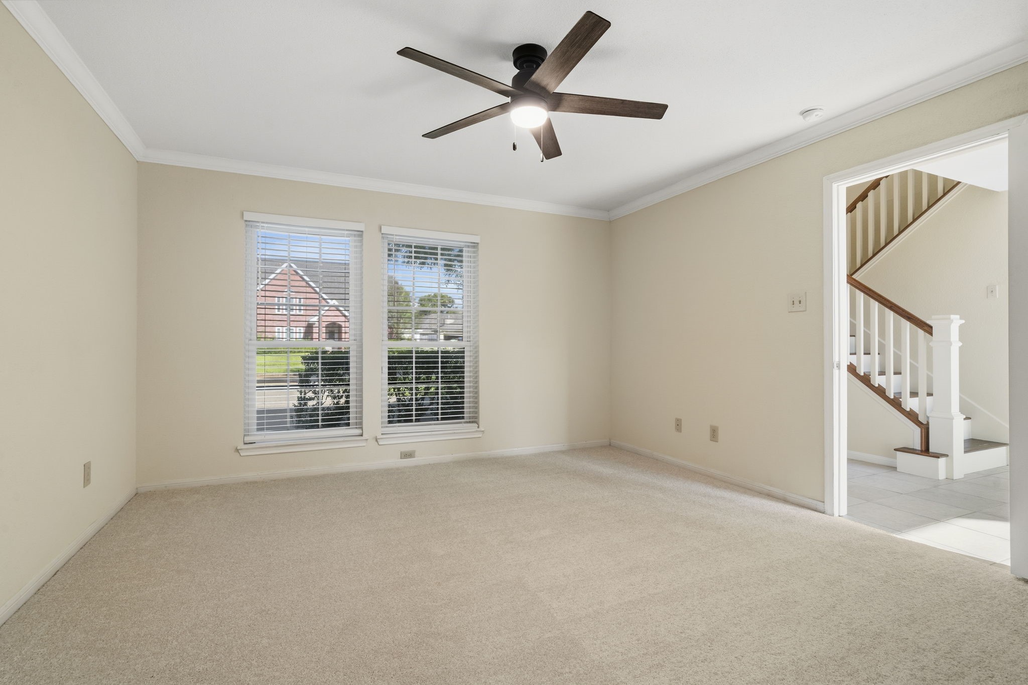 The first-floor primary suite offers a spacious retreat with new carpet, crown molding & plenty of natural light.