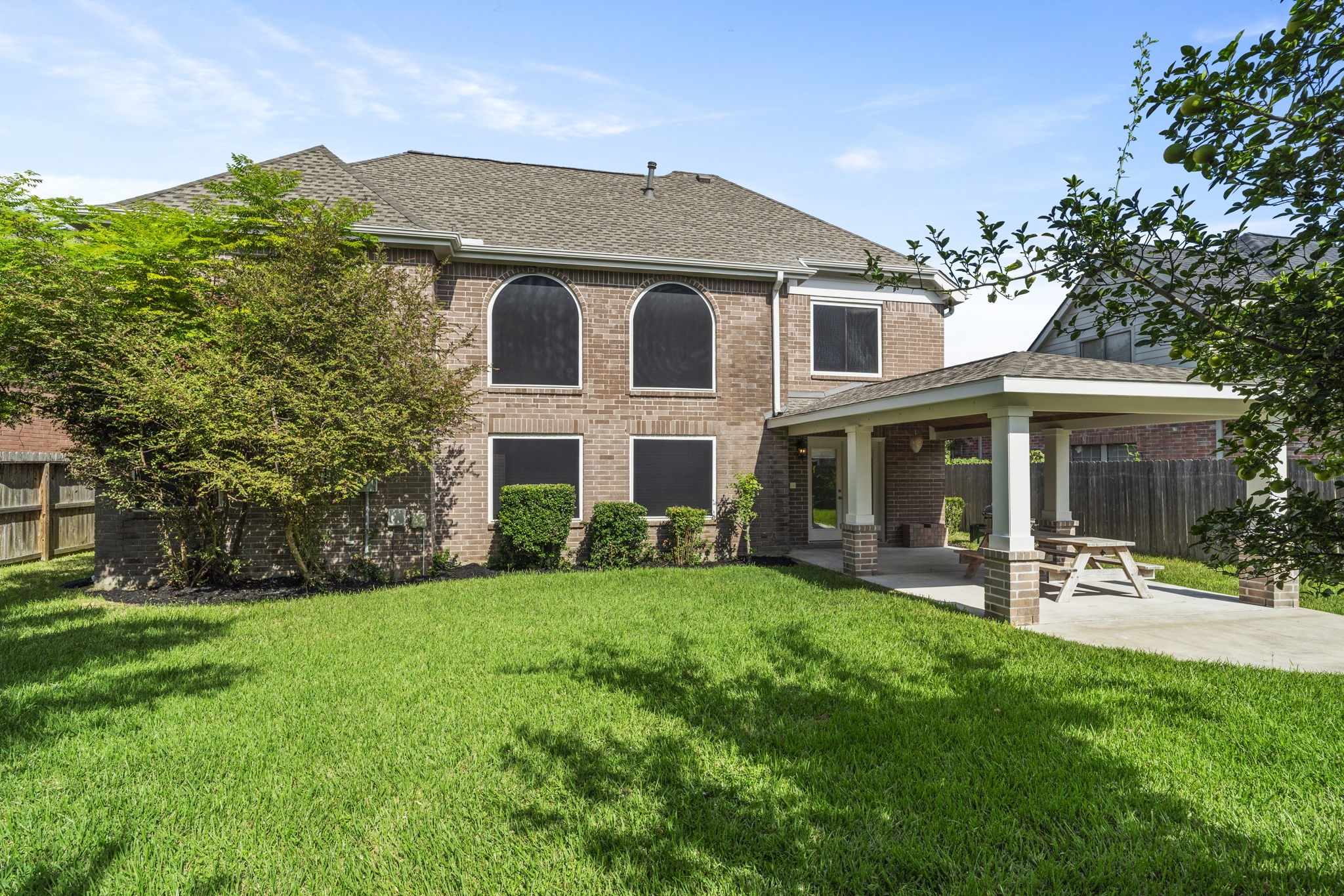Generous backyard offers plenty of green space with mature trees providing natural shade.