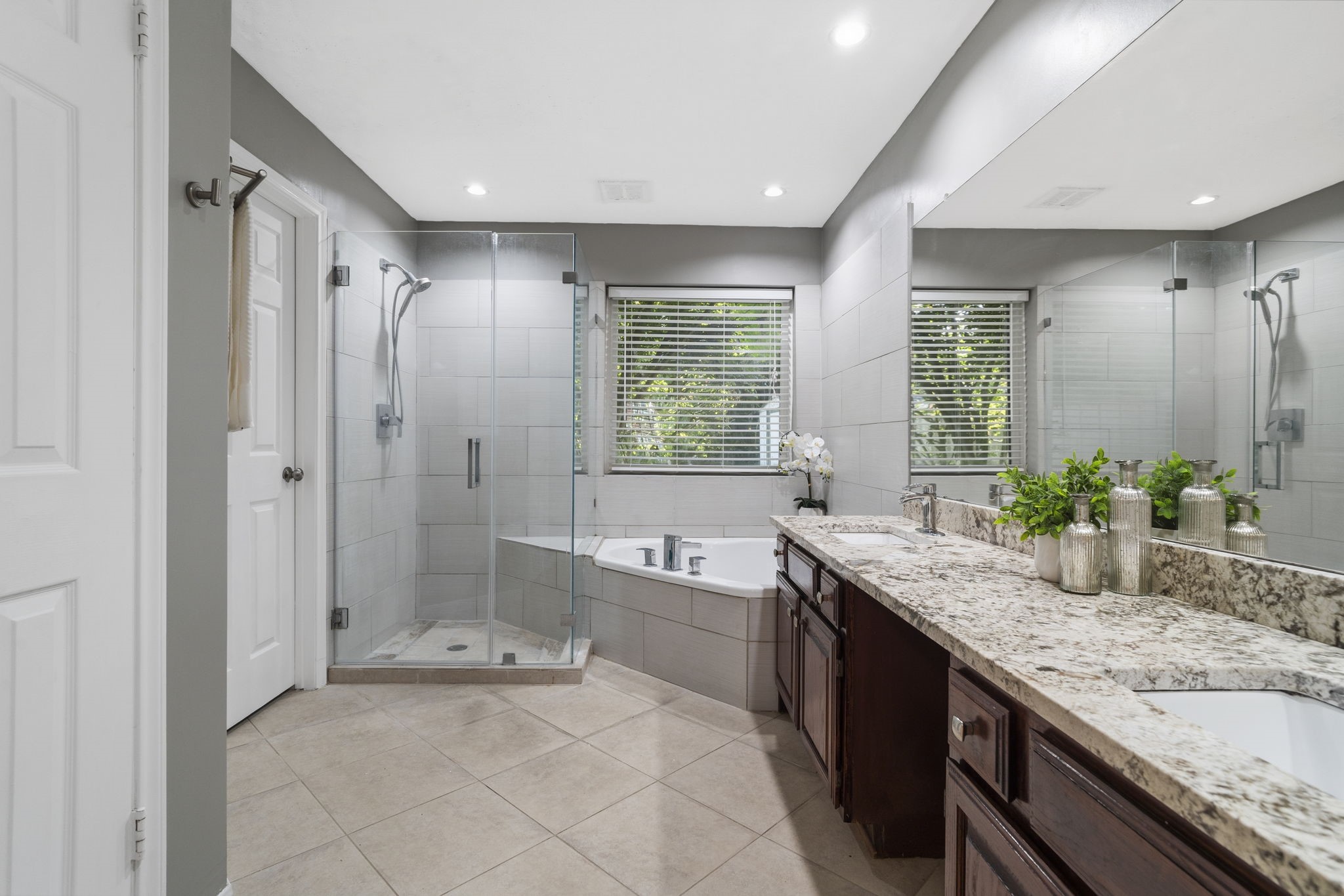 The updated primary bath features a frameless glass shower, soaking tub & dual vanities with granite countertops for a polished, functional retreat.