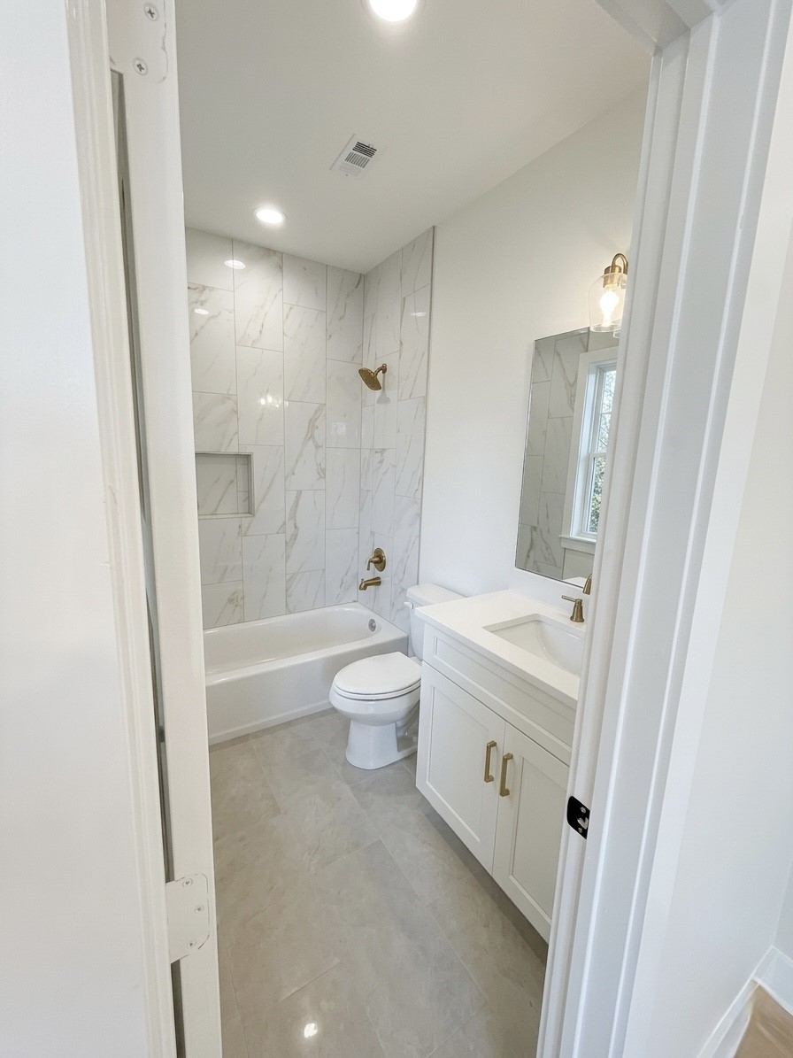 Elegant bathroom featuring a sleek marble-tiled shower, modern fixtures, and a stylish vanity for a touch of luxury.