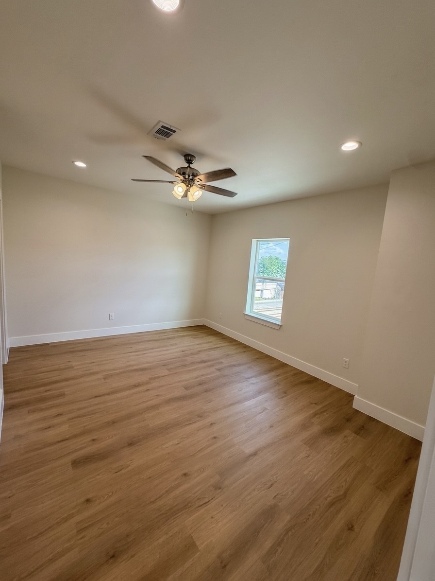 Bright and airy room featuring engineered hardwood floors, recessed lighting, and a ceiling fan for comfort.