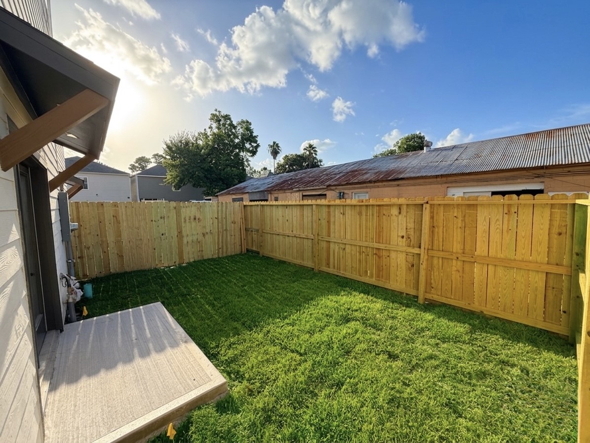Charming backyard with a privacy fence and lush green lawn, perfect for outdoor relaxation and entertaining.