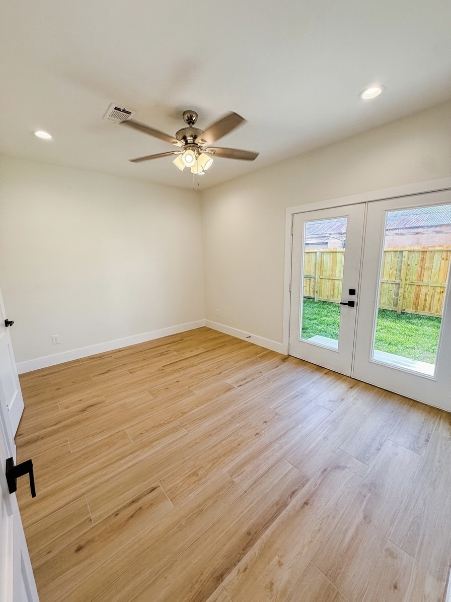 Bright and inviting room on 1st story with elegant porcelain flooring, a ceiling fan, and French doors opening to a private fenced yard.