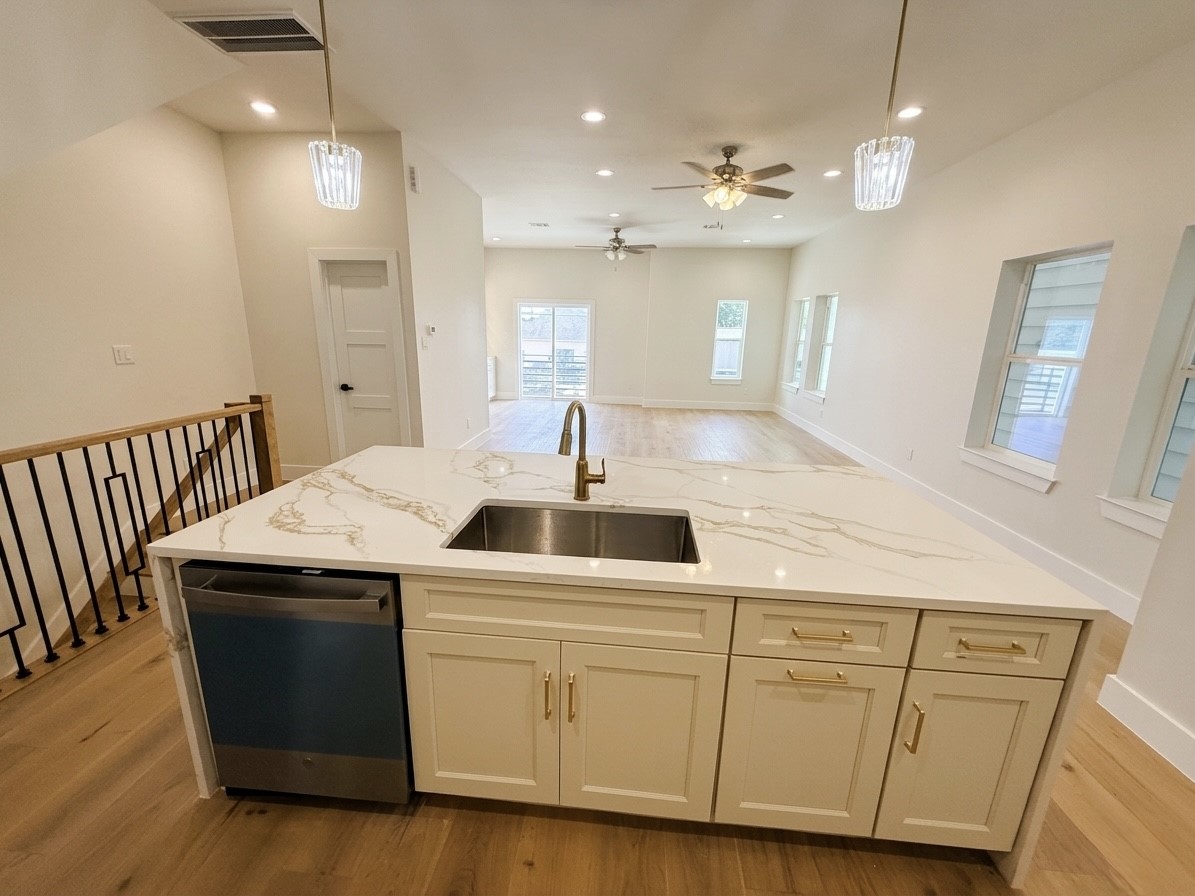 Bright and spacious open-concept living area featuring a stylish kitchen island with elegant countertops, modern fixtures, and ample natural light from multiple windows.