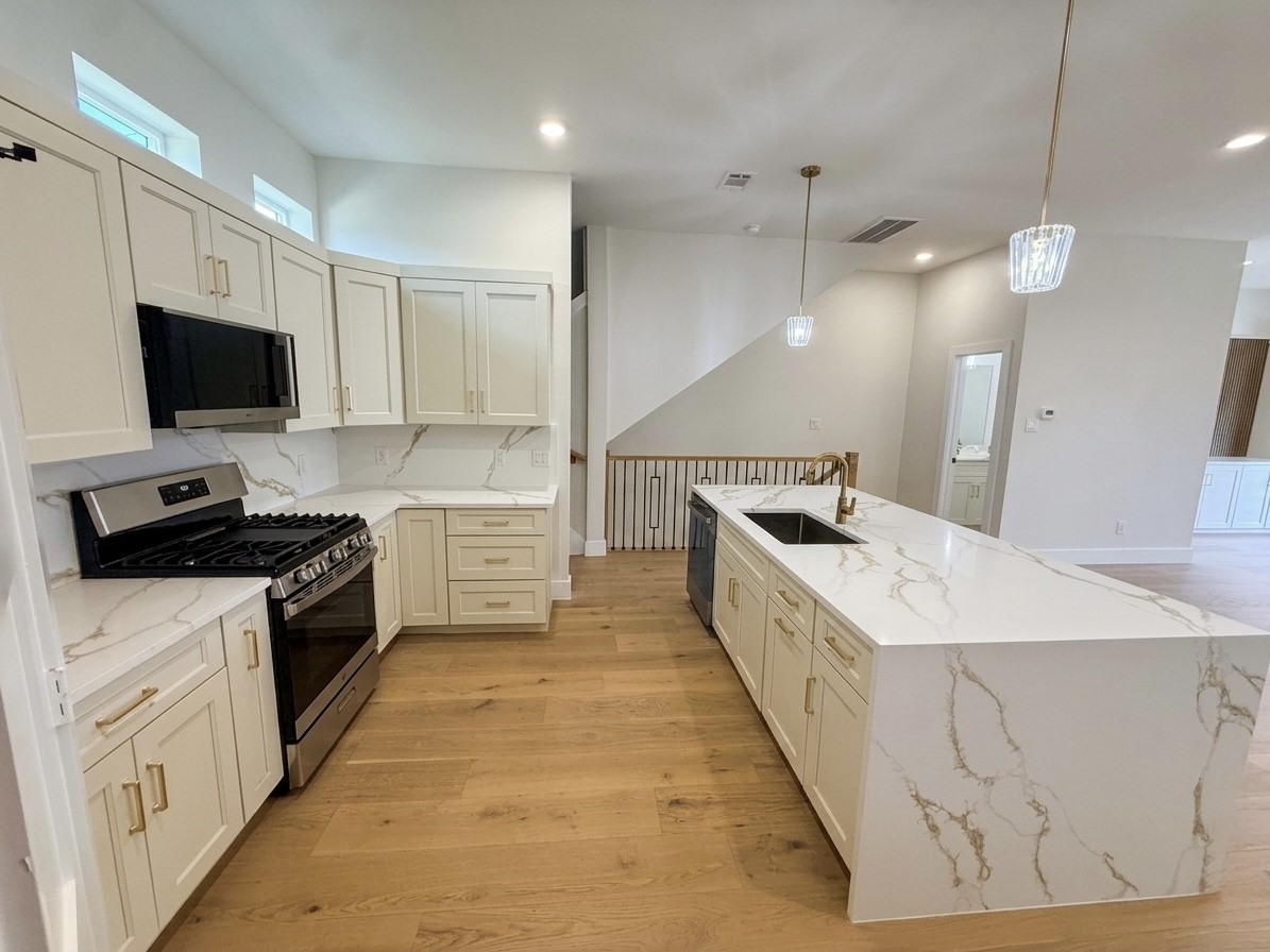 Bright and spacious kitchen featuring elegant quartz countertops, modern cabinetry, and stainless steel appliances, perfect for culinary enthusiasts.