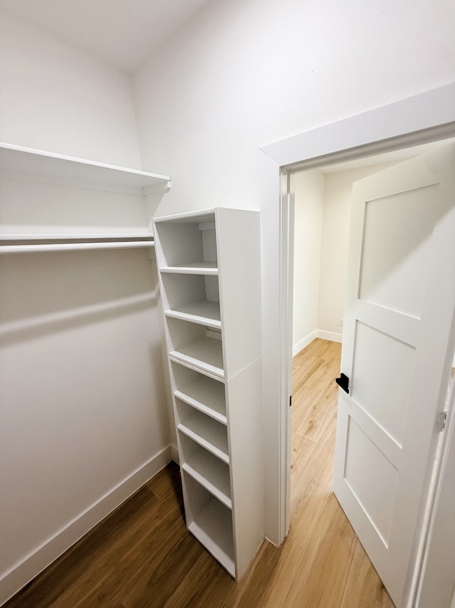 Spacious walk-in closet with built-in shelving and hanging space, featuring elegant.