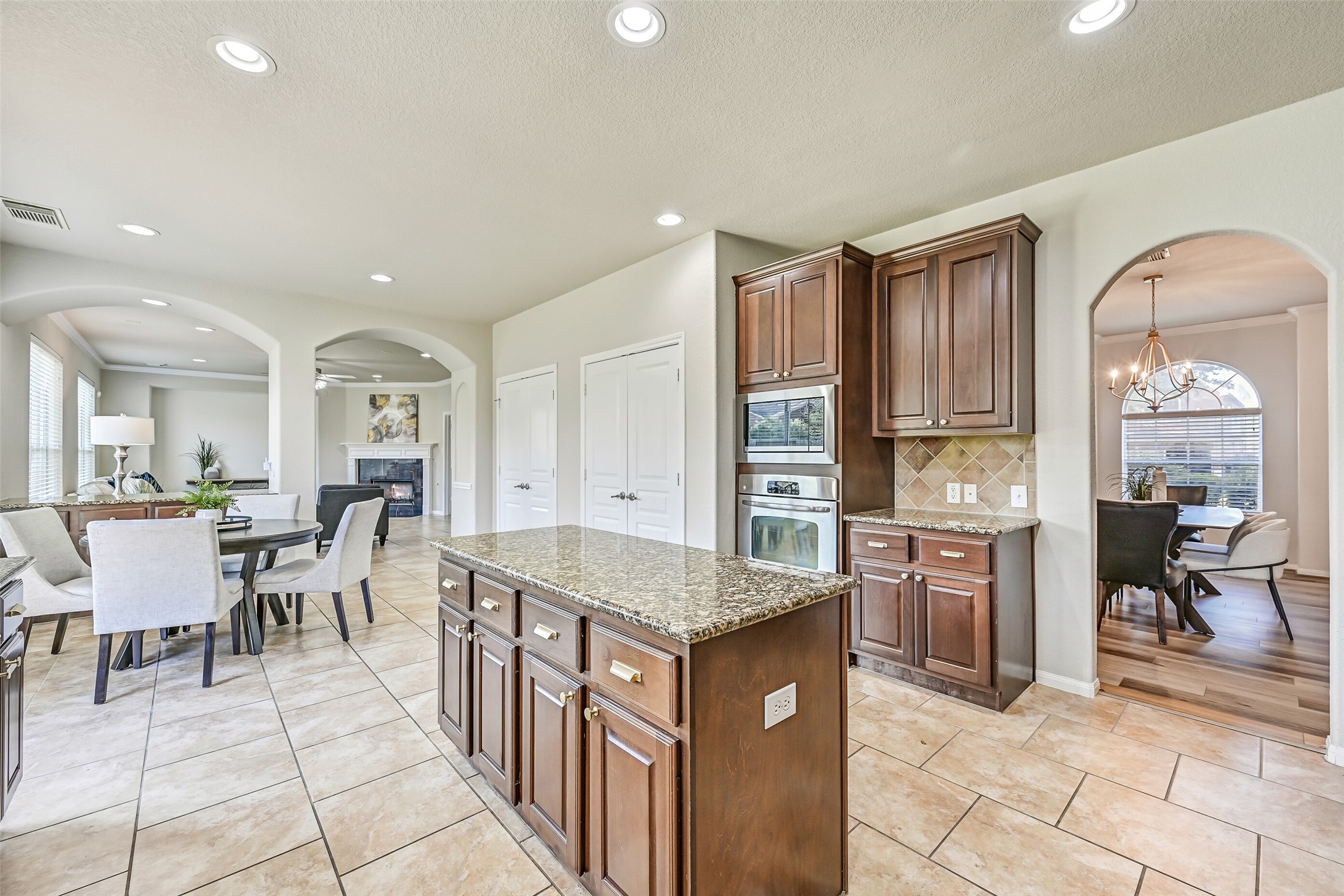 From this angle, appreciate the kitchen's generous footprint and exceptional storage options. Stainless built-in appliances, extensive cabinetry, and not one but two oversized double-door pantries make organization effortless, while the open flow keeps you connected to both the breakfast area and family room.