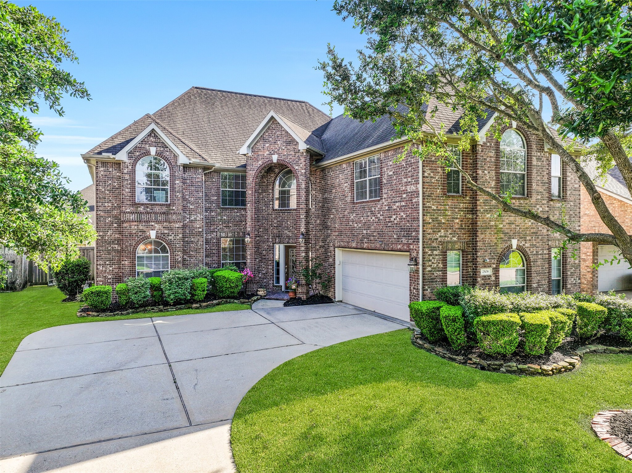 A sweeping driveway leads to the two-car garage and covered entry of this spacious family home. Graceful architectural details, soaring arched windows, and well-maintained landscaping create a warm first impression, while the freshly painted exterior adds a crisp, move-in-ready feel.