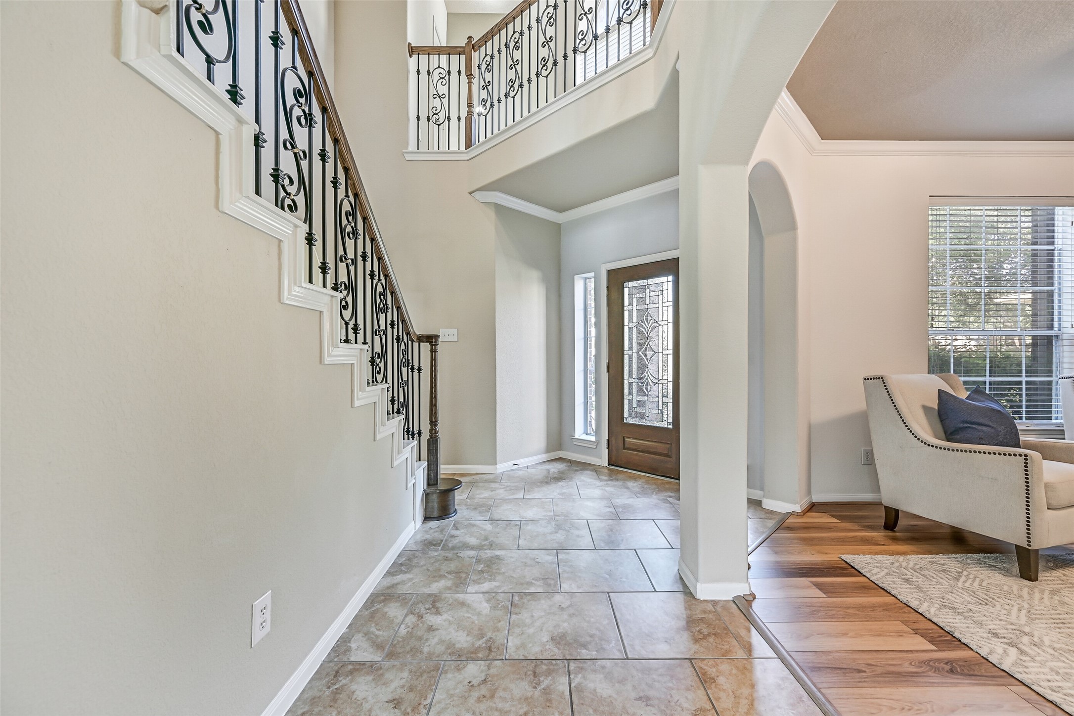 From the foyer, notice the graceful arched openings, soaring ceiling, and open sightlines that set the tone for this spacious floorplan. Fresh interior paint provides a clean, move-in-ready backdrop, while the staircase serves as a stunning architectural centerpiece connecting both levels of the home.