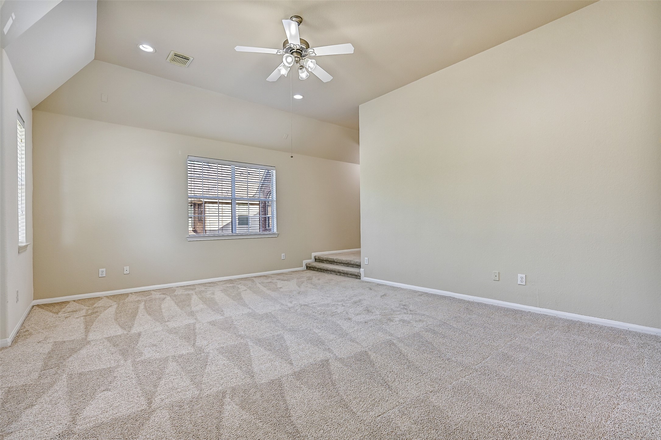 Tucked away on the second floor, this expansive game room offers endless flexibility for the way you live. Fresh carpet, a lighted ceiling fan, surround sound wiring, and soaring vaulted ceilings create an inviting atmosphere, while the elevated rear section provides the perfect spot for a media area, gaming setup, reading nook, or homework station.