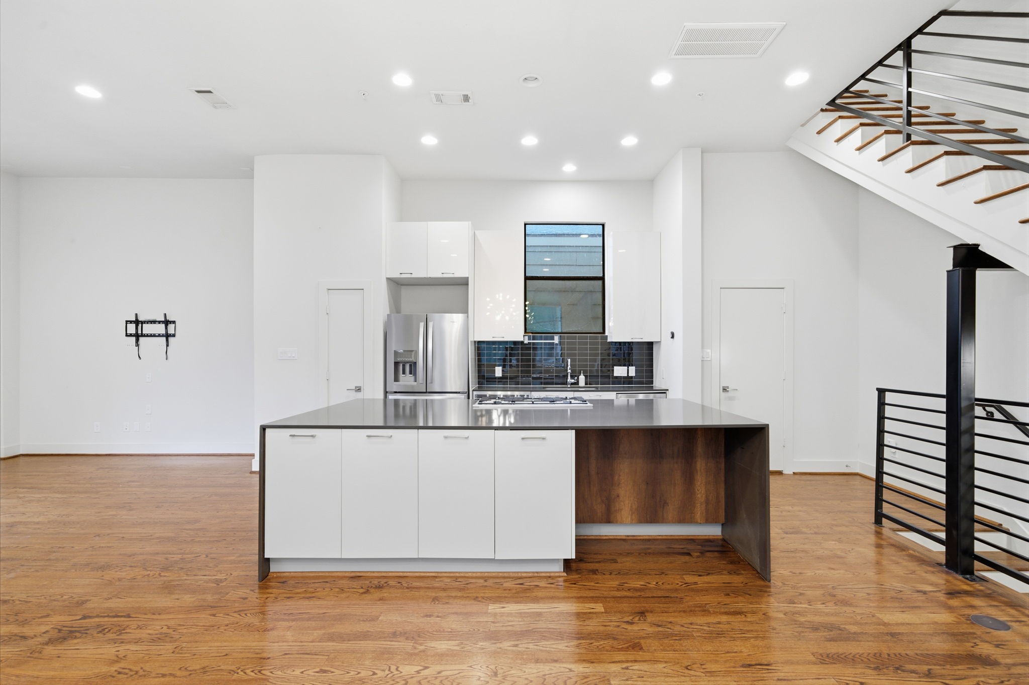 HUGE kitchen island with seating. All stainless steel appliances (fridge will convey). QUARTZ counters in kitchen + baths. Door on the left (next to fridge) is the pantry. Door on the right is half bath for this floor - tucked away into a corner, but still conveniently close by!