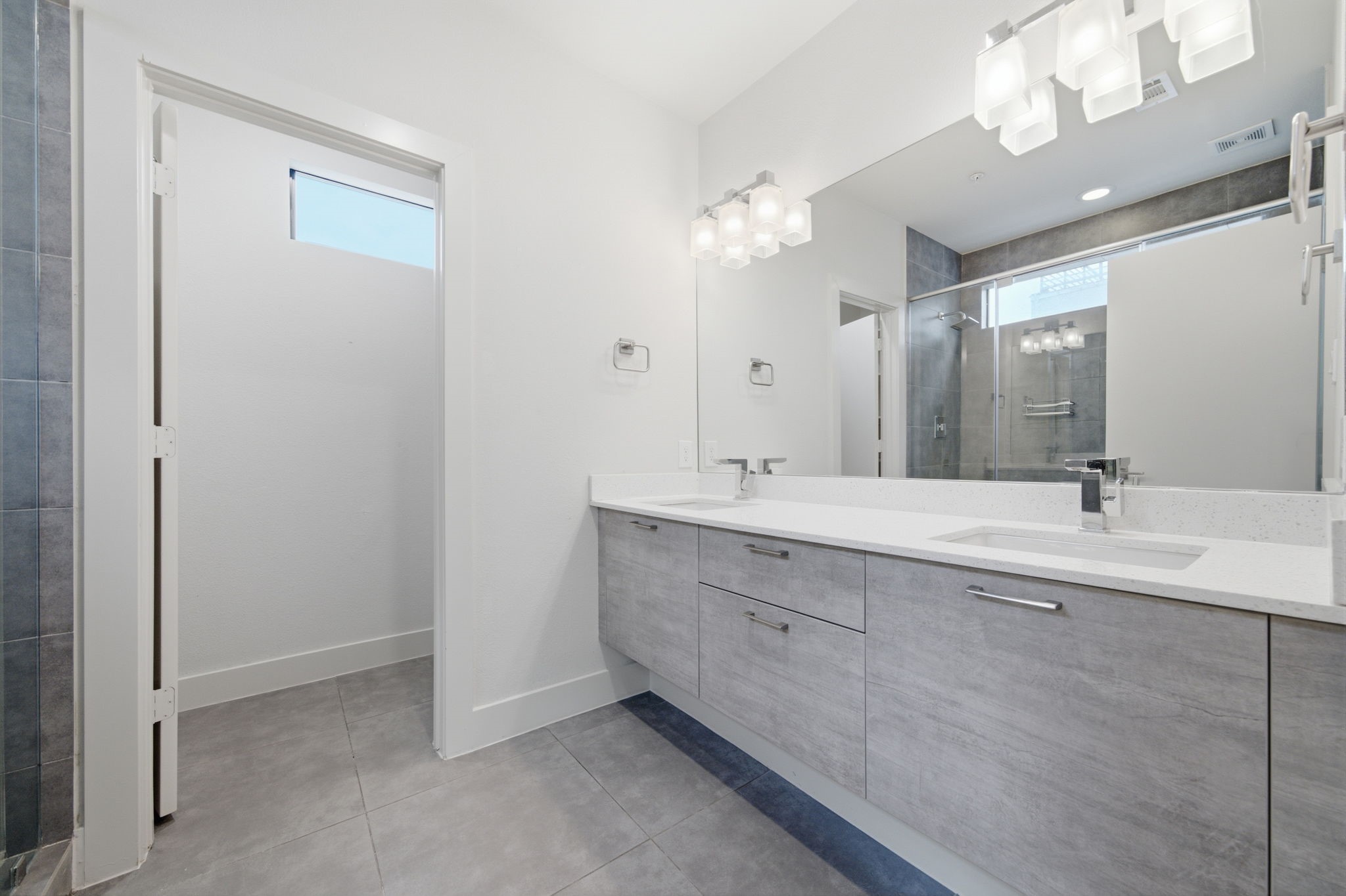 Double sinks, quartz counters and plenty of storage! WC tucked into the corner (through the door) for privacy!