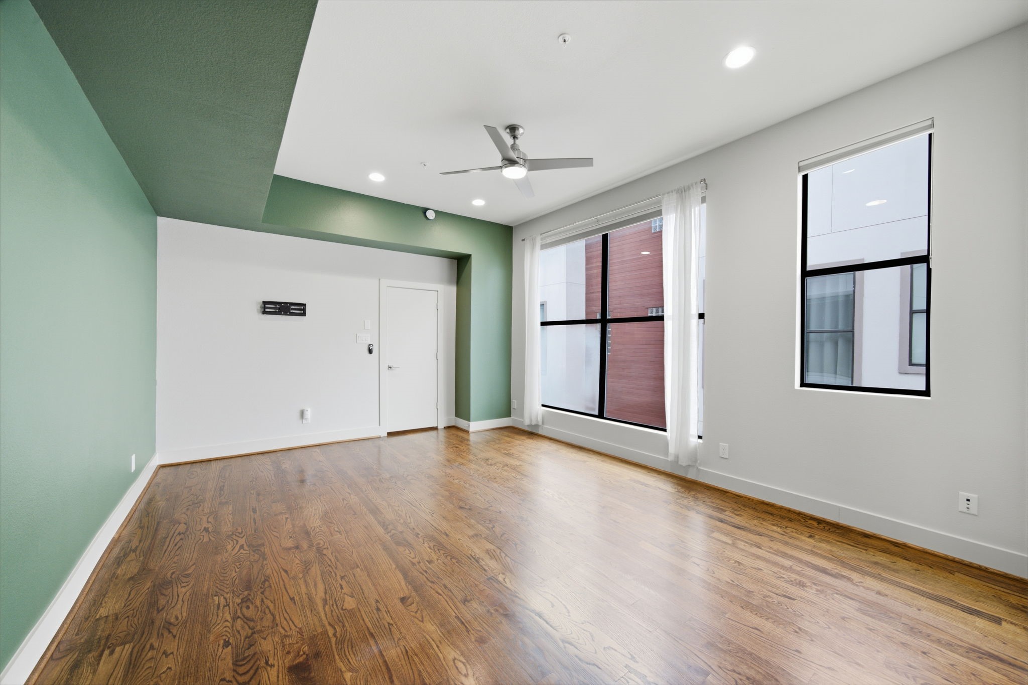 3rd floor - This is your Primary Bedroom OASIS! HUGE WINDOWS letting in so much natural light! Deep green paint and WOOD floors anchoring the space!
