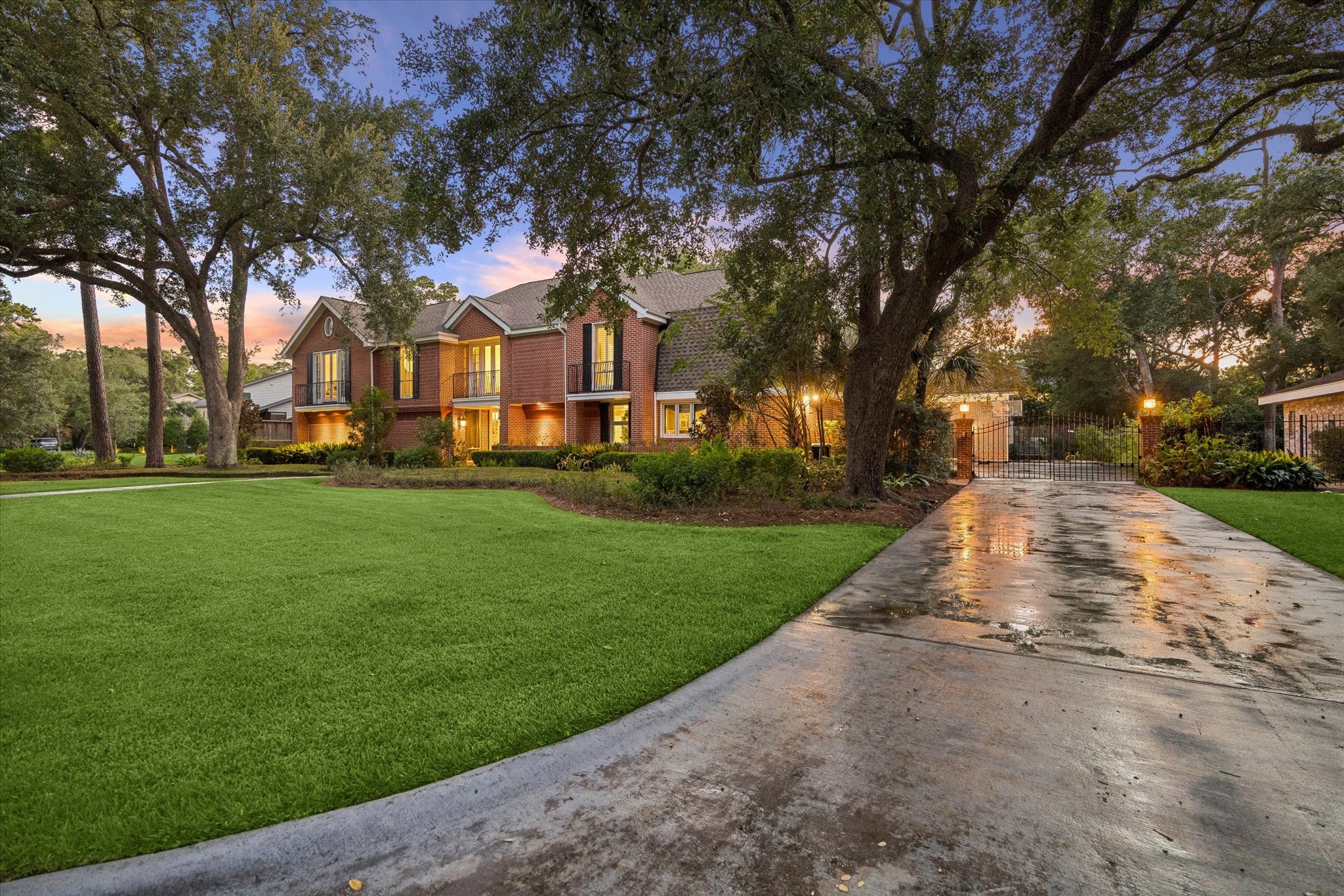 Long driveway leading to a gated motor court and three-car garage.
