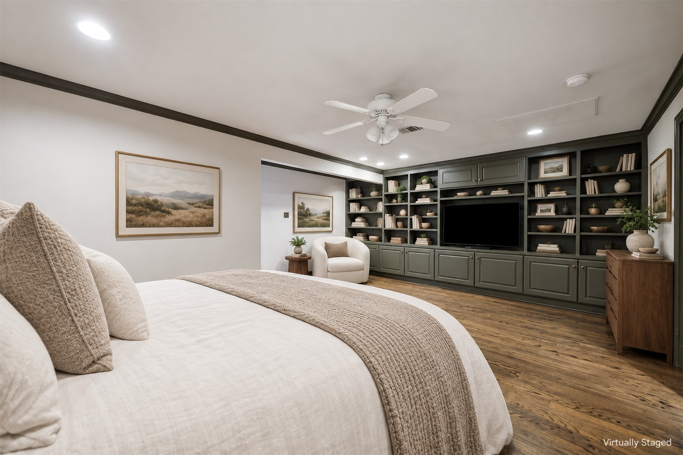 Virtually Staged - Spacious primary bedroom features elegant oak flooring and a cozy seating area.