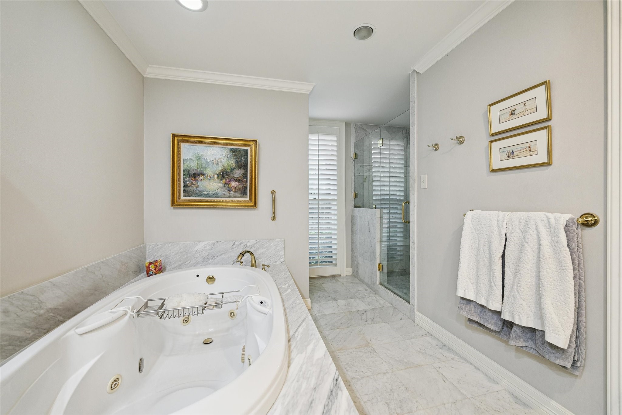 A whirlpool tub, a sleek glass-enclosed shower, and sophisticated marble finishes for a serene retreat.