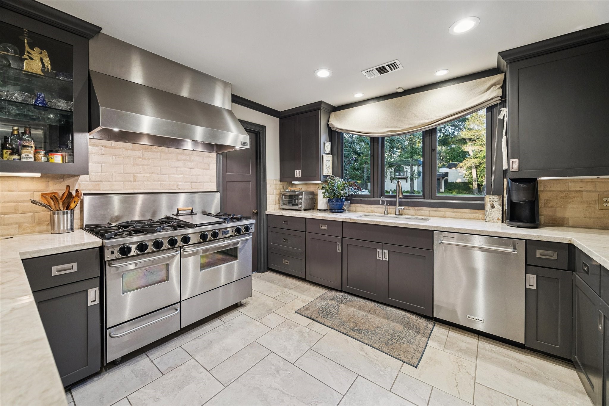 Kitchen features a professional-grade stainless steel range and vent hood.