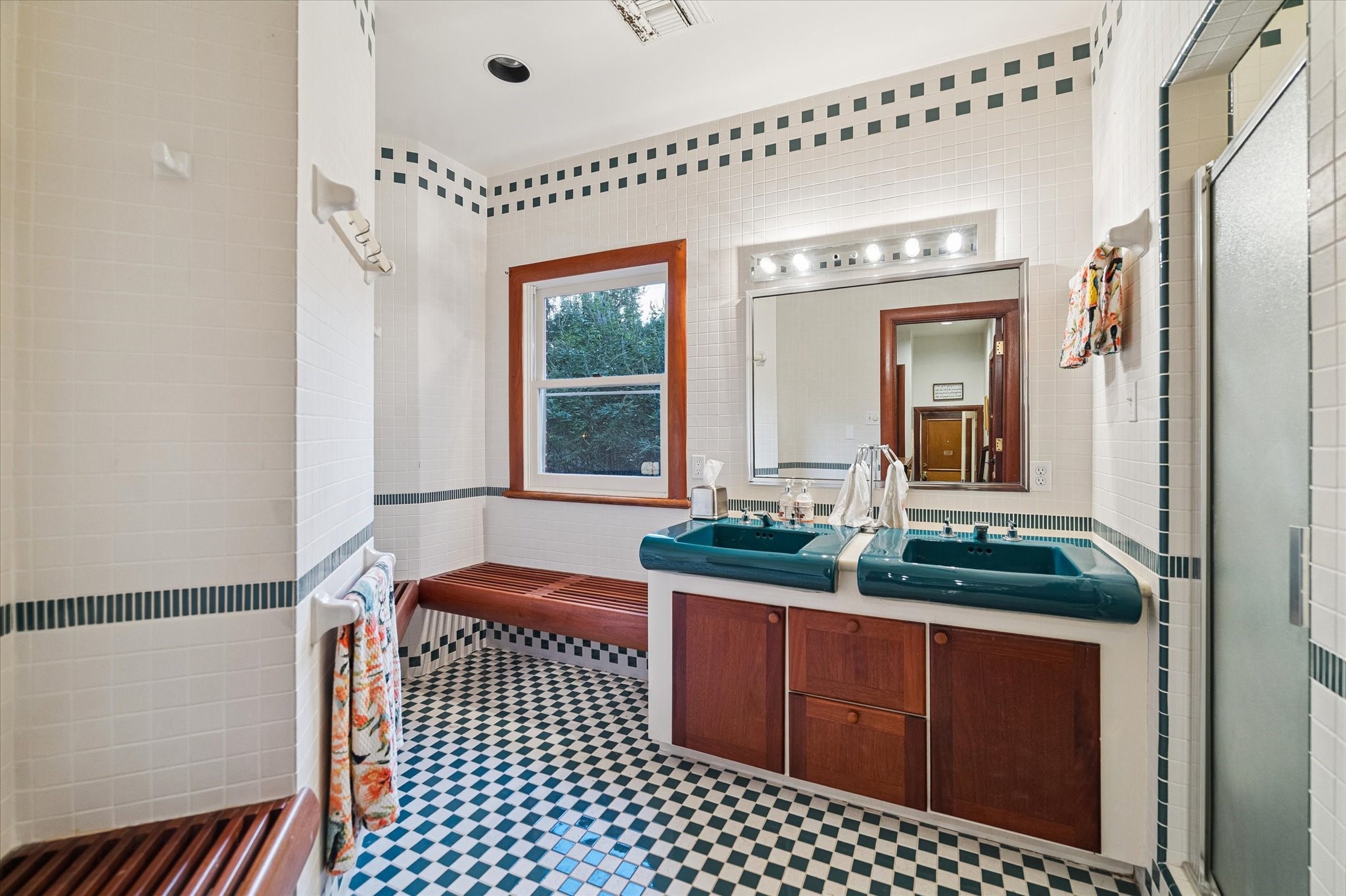 Full bath with dual vanities, oversized shower, and private water closet.