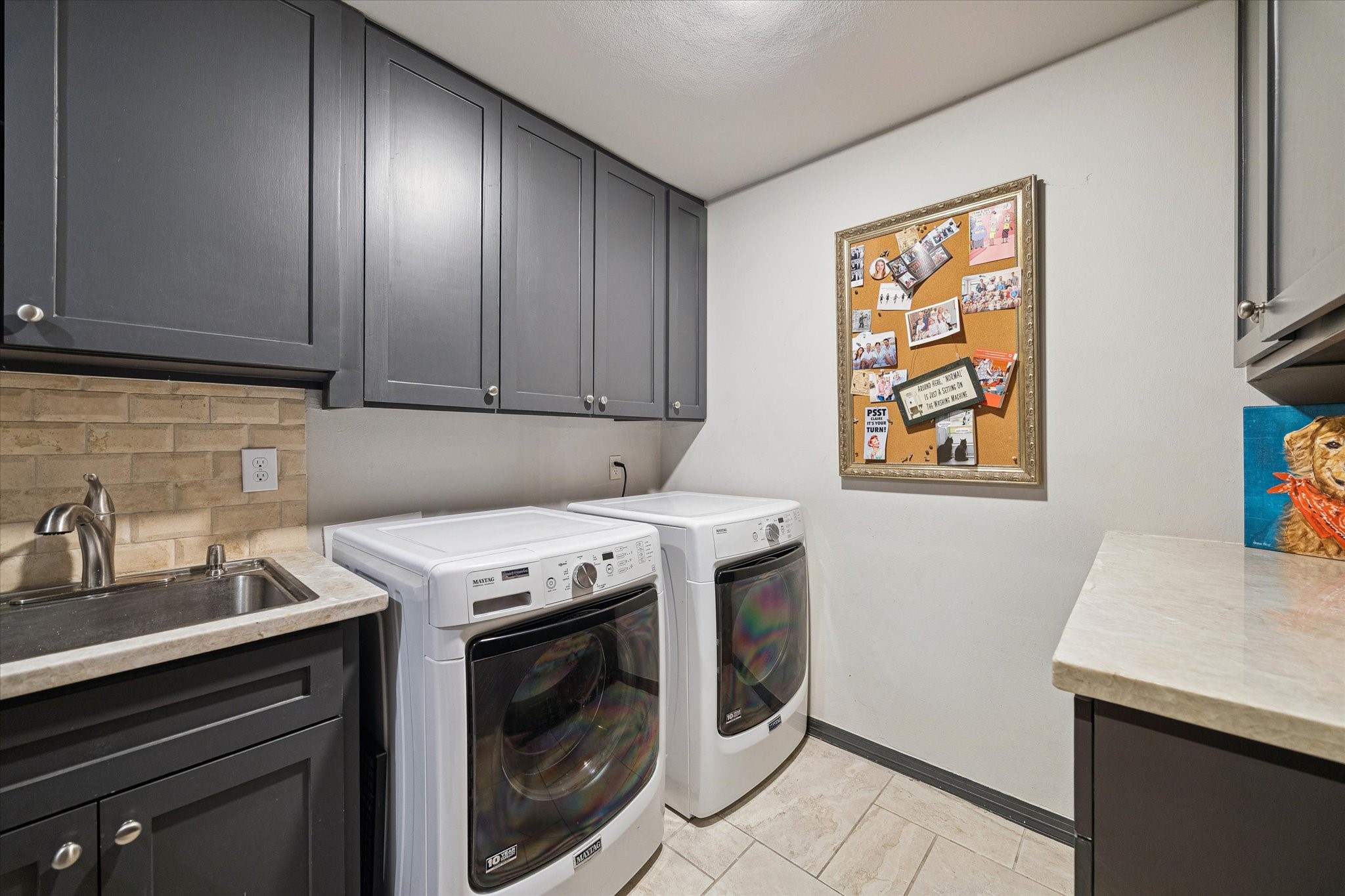 Manage household chores in this well-appointed utility room featuring updated cabinetry and ample counter space for all your organizational needs.
