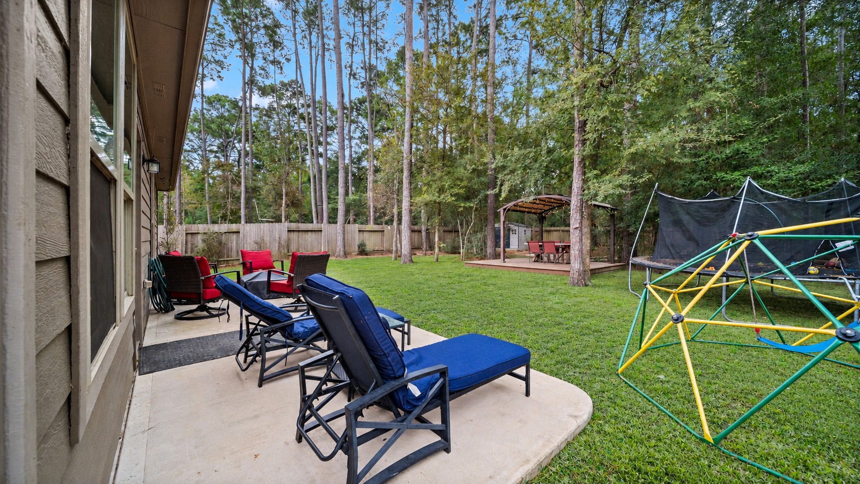 our own backyard retreat! Enjoy a spacious, fully fenced yard surrounded by beautiful mature trees, with plenty of room to relax and enjoy the outdoors. Outdoor furniture, trampoline, and climbing structure not included.