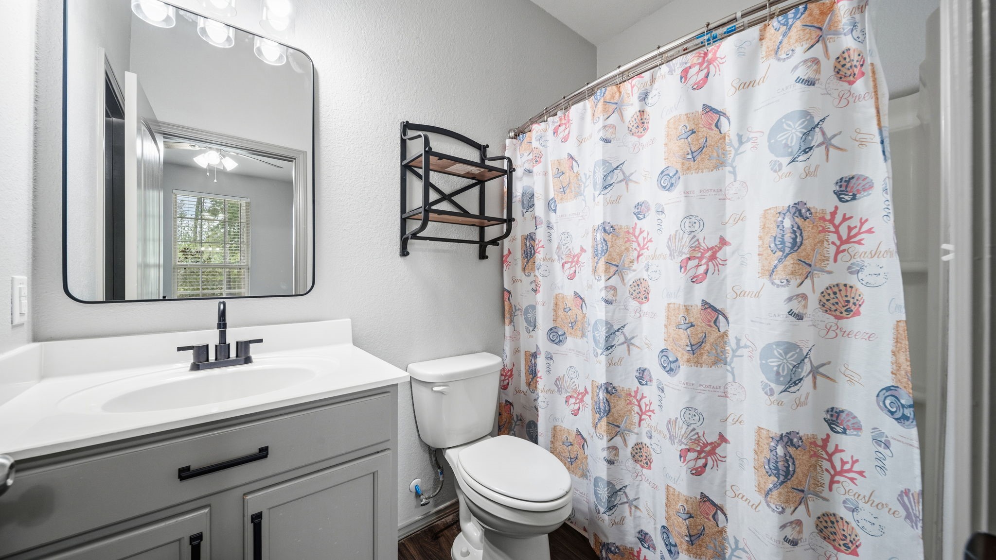 Enjoy the convenience of a private bathroom adjoining the second primary bedroom, complete with a modern vanity and tub/shower combination.