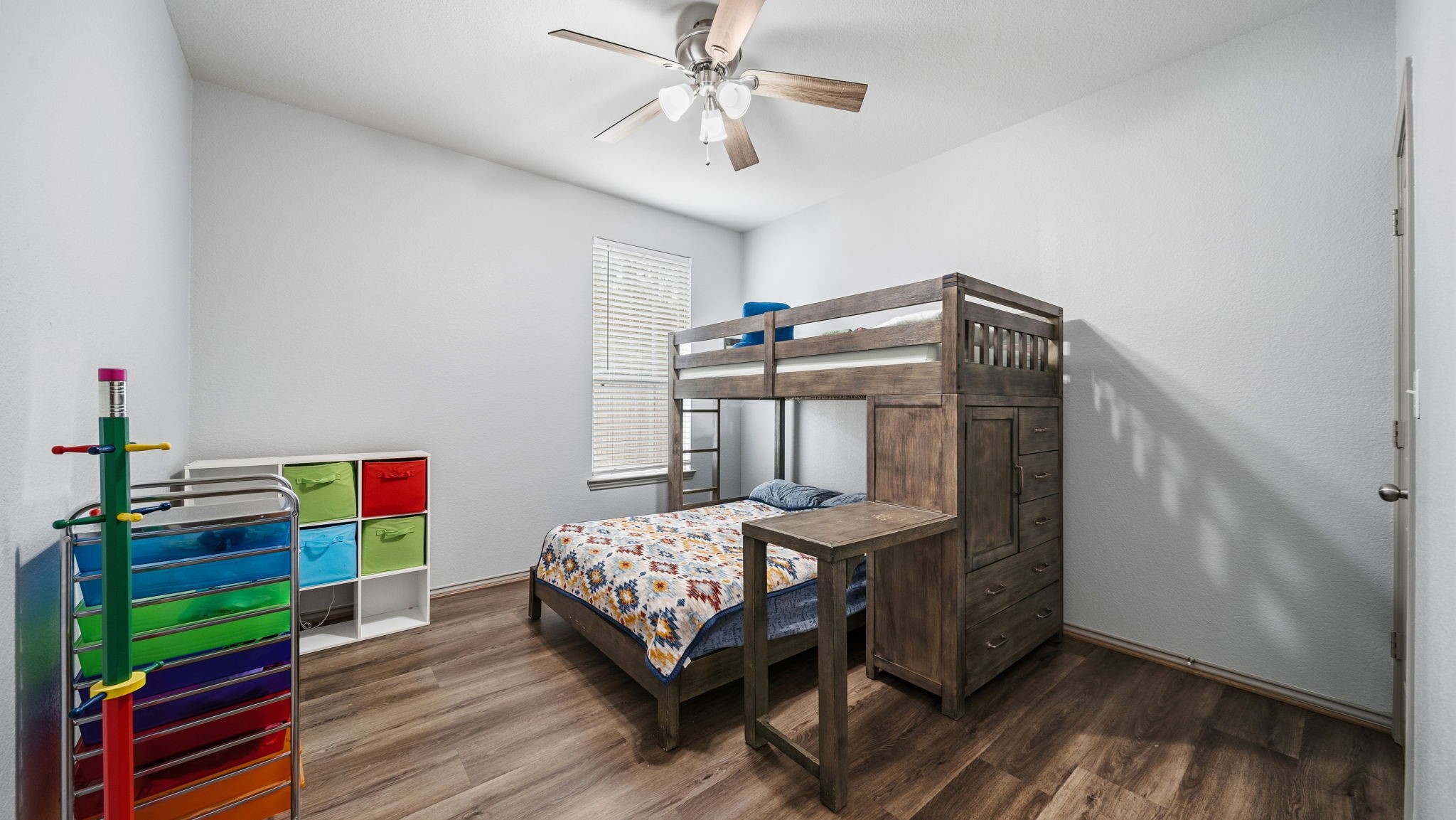 Bright and comfortable bedroom featuring a ceiling fan, natural light, and beautiful flooringno carpet to worry about!