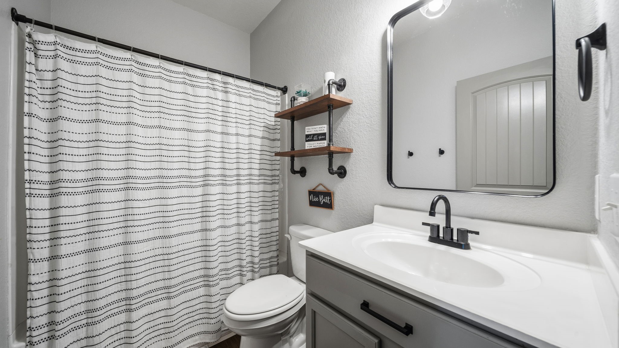 Fresh, inviting bathroom featuring an updated vanity, modern black fixtures, and a convenient tub/shower combination.