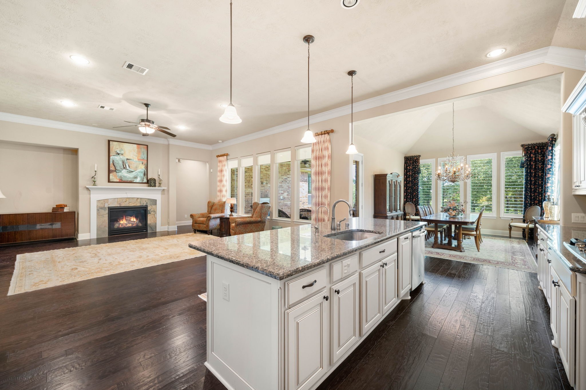 An open layout connects the kitchen to the living and dining areas, anchored by the home's second gas log fireplace.