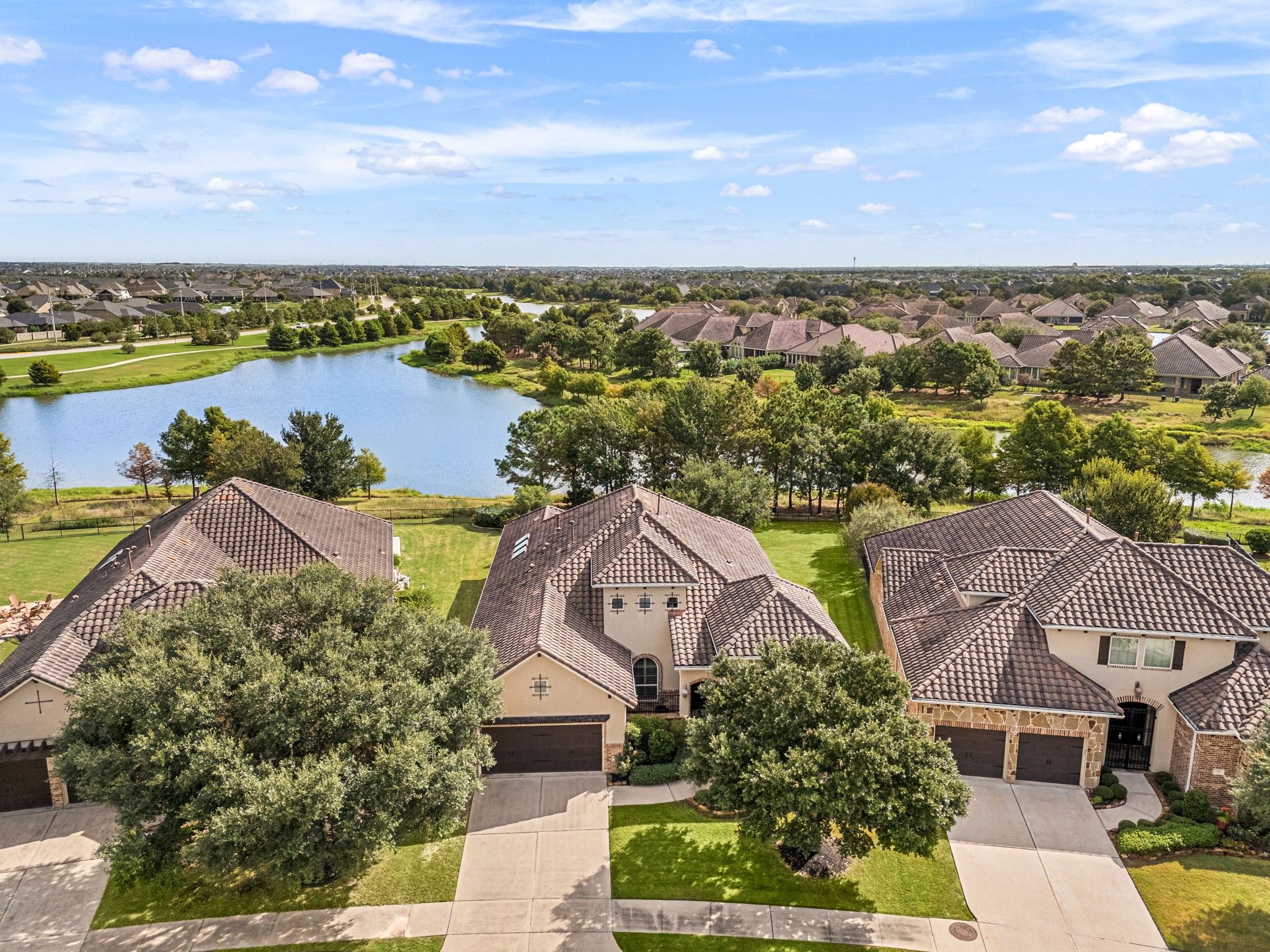This bird's-eye perspective showcases the home's setting on a spacious lot, just steps from the community's scenic lake.