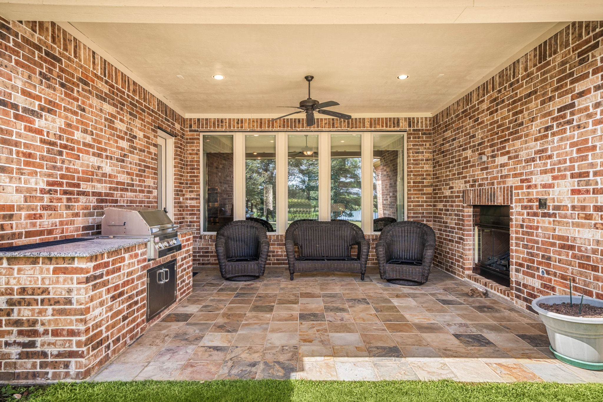 The covered patio is built for entertaining, complete with an outdoor kitchen, a gas log fireplace, and a ceiling fan for year-round comfort.