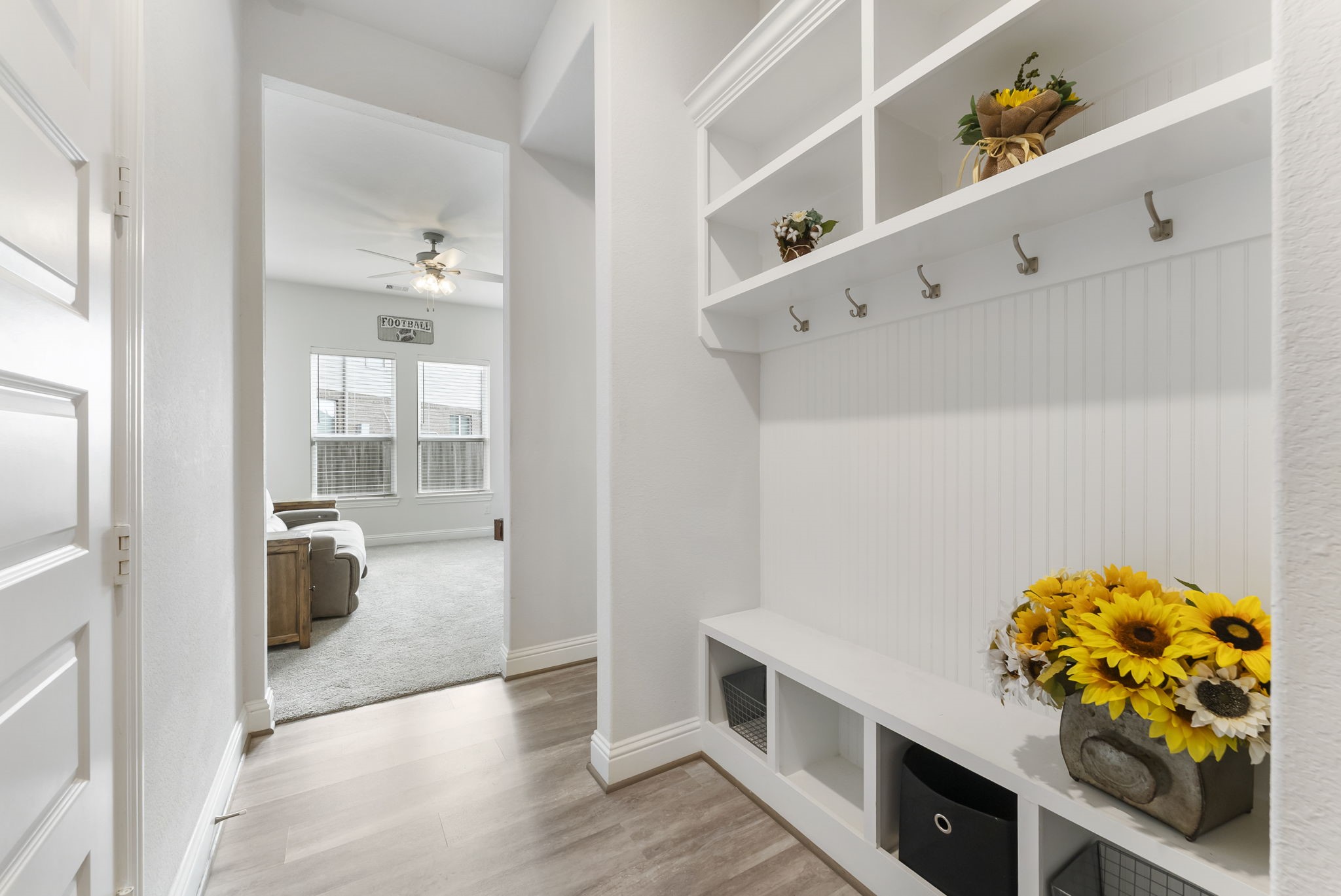 Mudroom located just inside the garage entrance, with a flex room and half bath down the hall