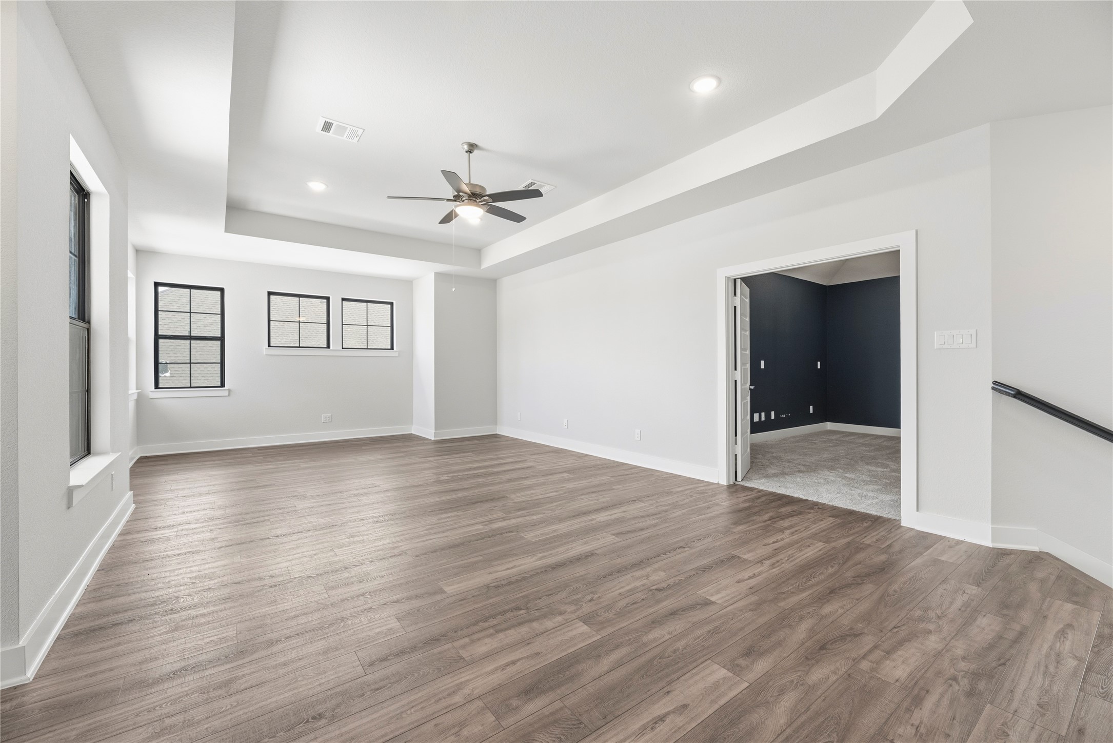 Open layout showing the seamless transition between the main upstairs living area and the adjacent flex/media room through elegant French doors.