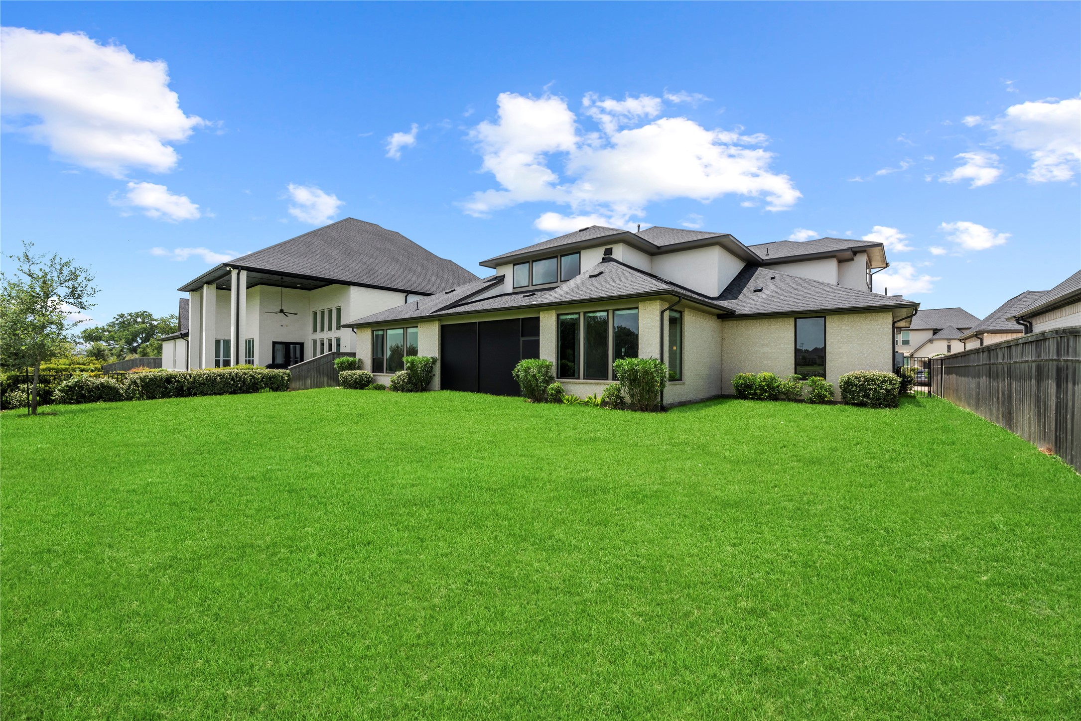 Wide angle view of the private rear lawnperfect for kids, pets, or future outdoor additionsframed by quality wood fencing and open sky.