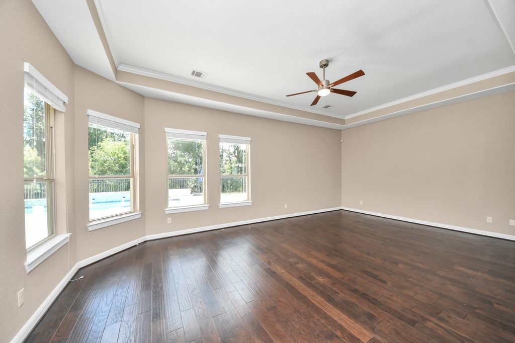 There is a large sitting area in the primary suite, with a tray ceiling and gorgeous views of the pool.