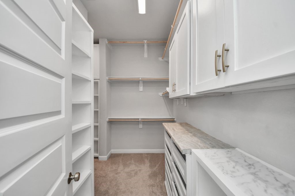 One of the TWO closets in the primary suite, custom shelving, cabinetry & drawers in this one!