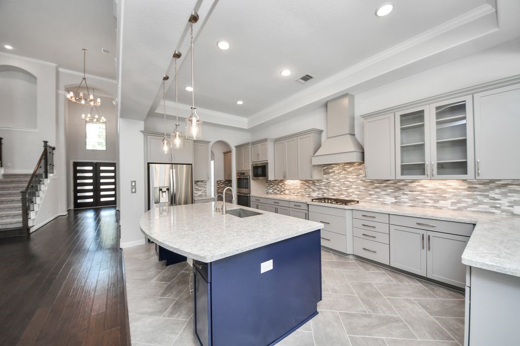 Glass front cabinets, pendant lighting, under cabinet lighting and double ovens are just some of the custom features this home has to offer. The refrigerator is also included.