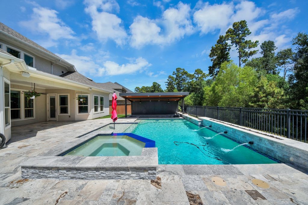 Pool & spa with fire pit feature, waterfall & tanning shelf.