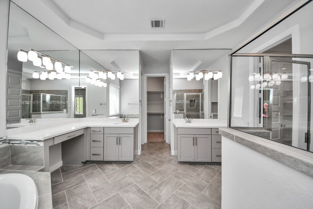 The primary bath has a large walk-in shower, double vanities & sinks.