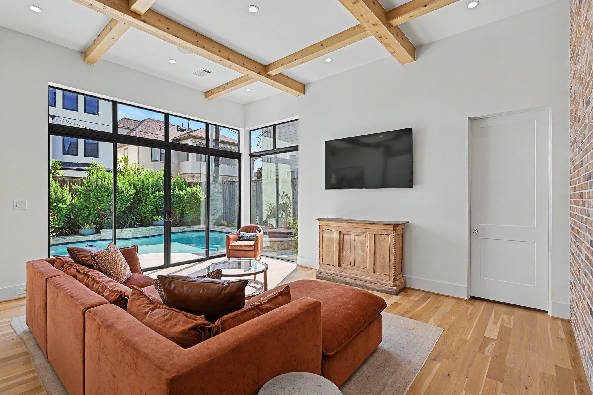Walls of glass connect the living room to the pool, creating a seamless indoor-outdoor experience.