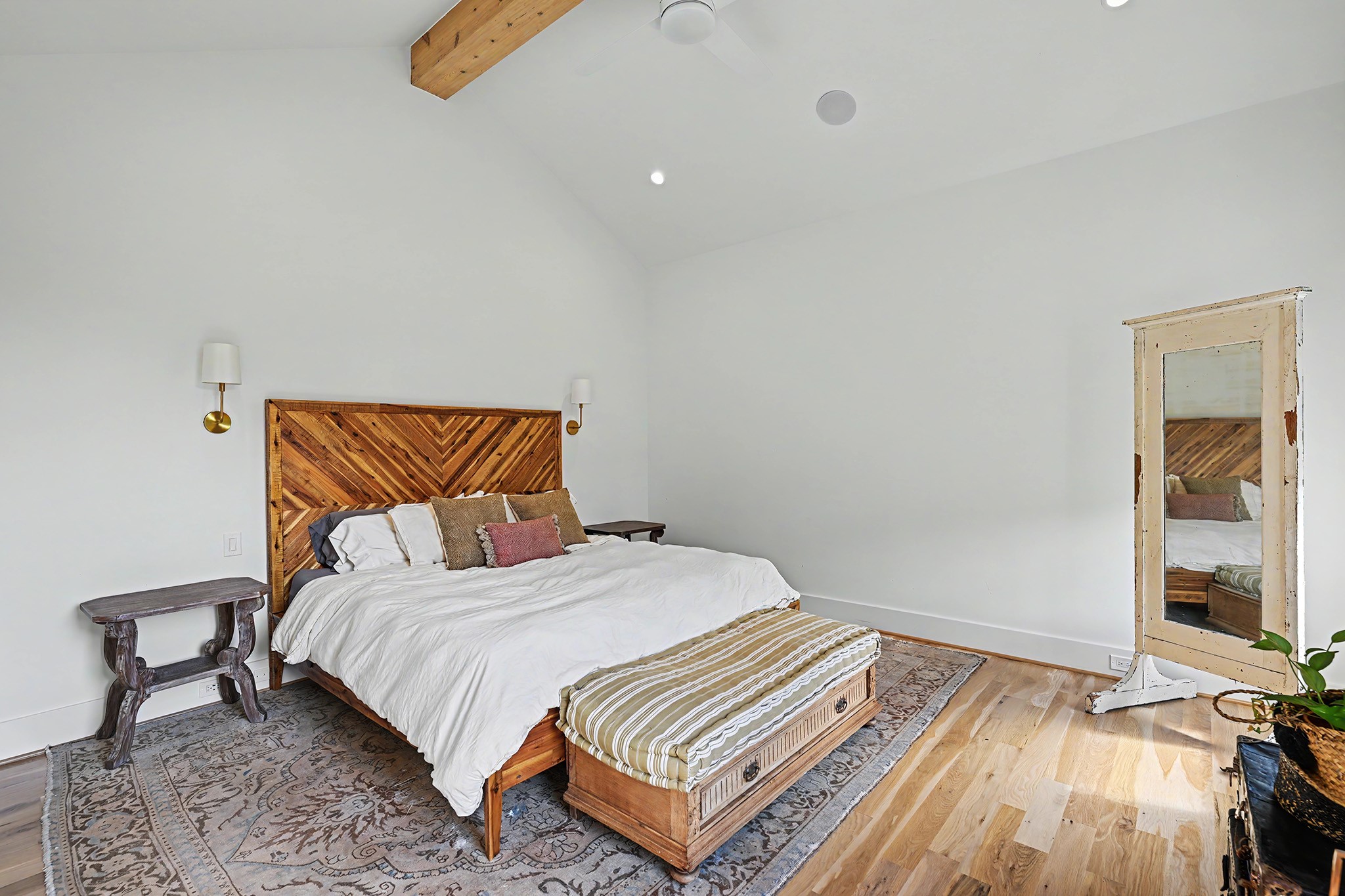 Light-stained cedar beams bring warmth and dimension to the serene primary bedroom.